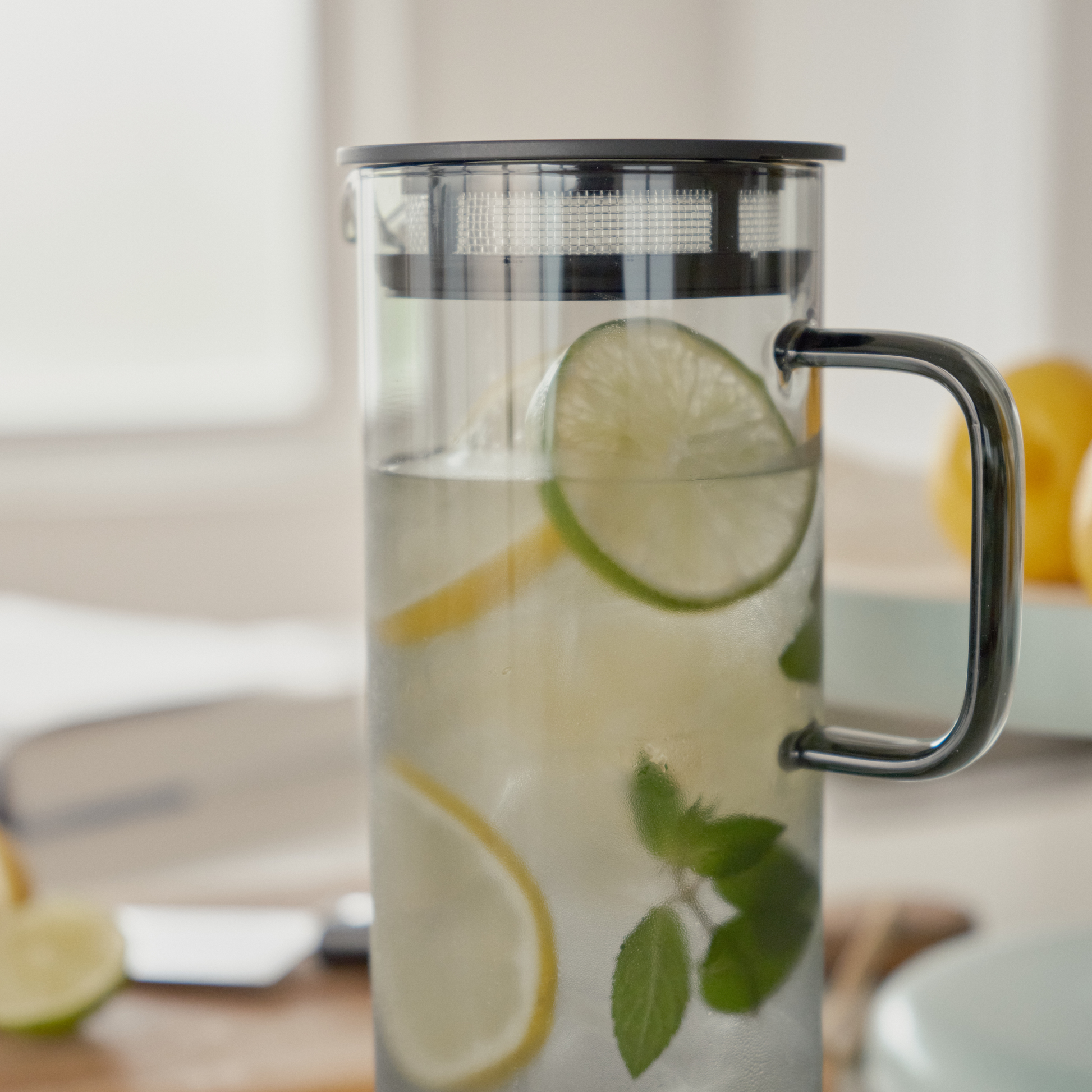 Close up of the Hario Glass Pitcher Grey that is made from heatproof glass with 800ml capacity, with a lid that has a mesh filter, with lemon juice inside.