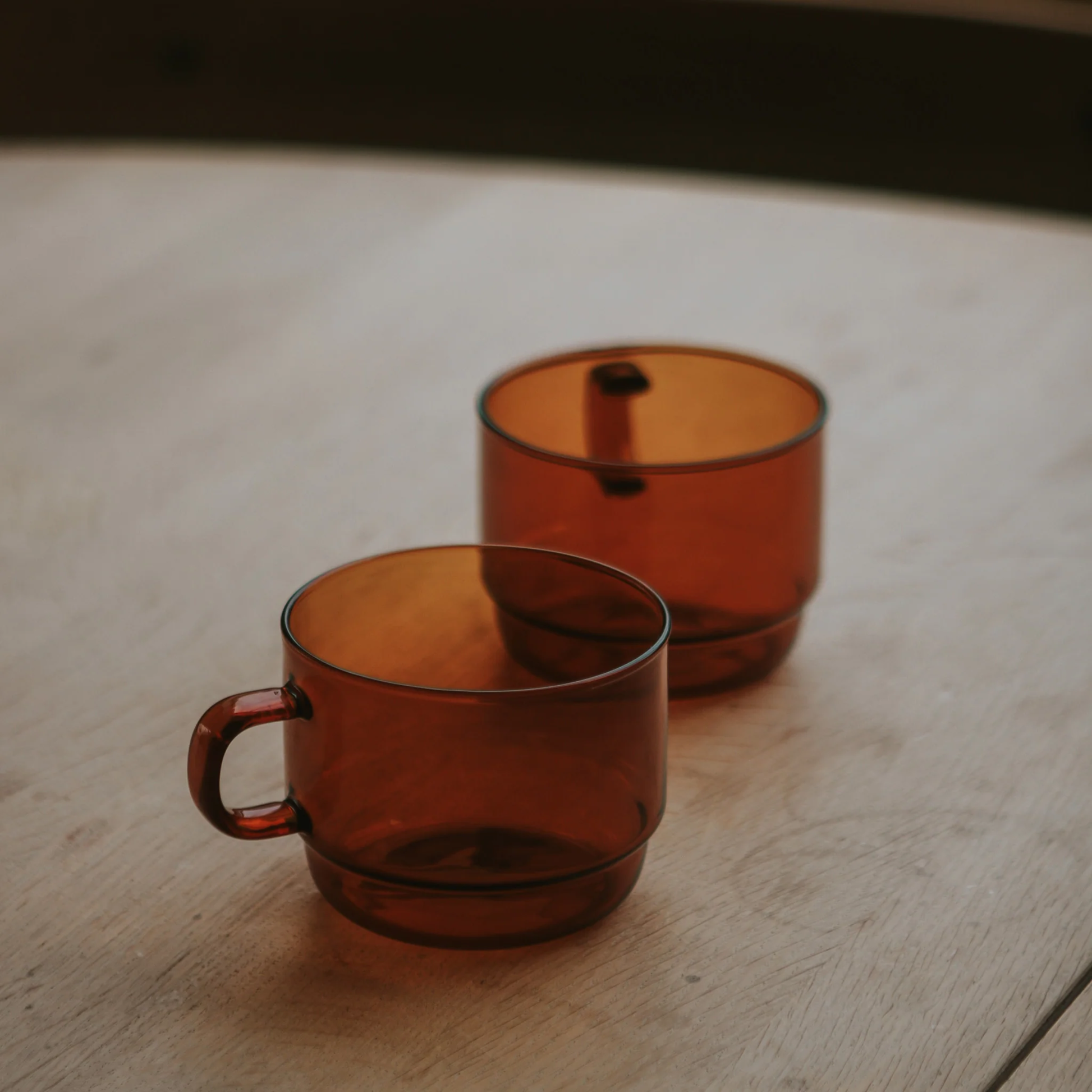 Two Hario Glass Stacking Mug Amber on the table that is made from heatproof glass, for 300ml capacity.