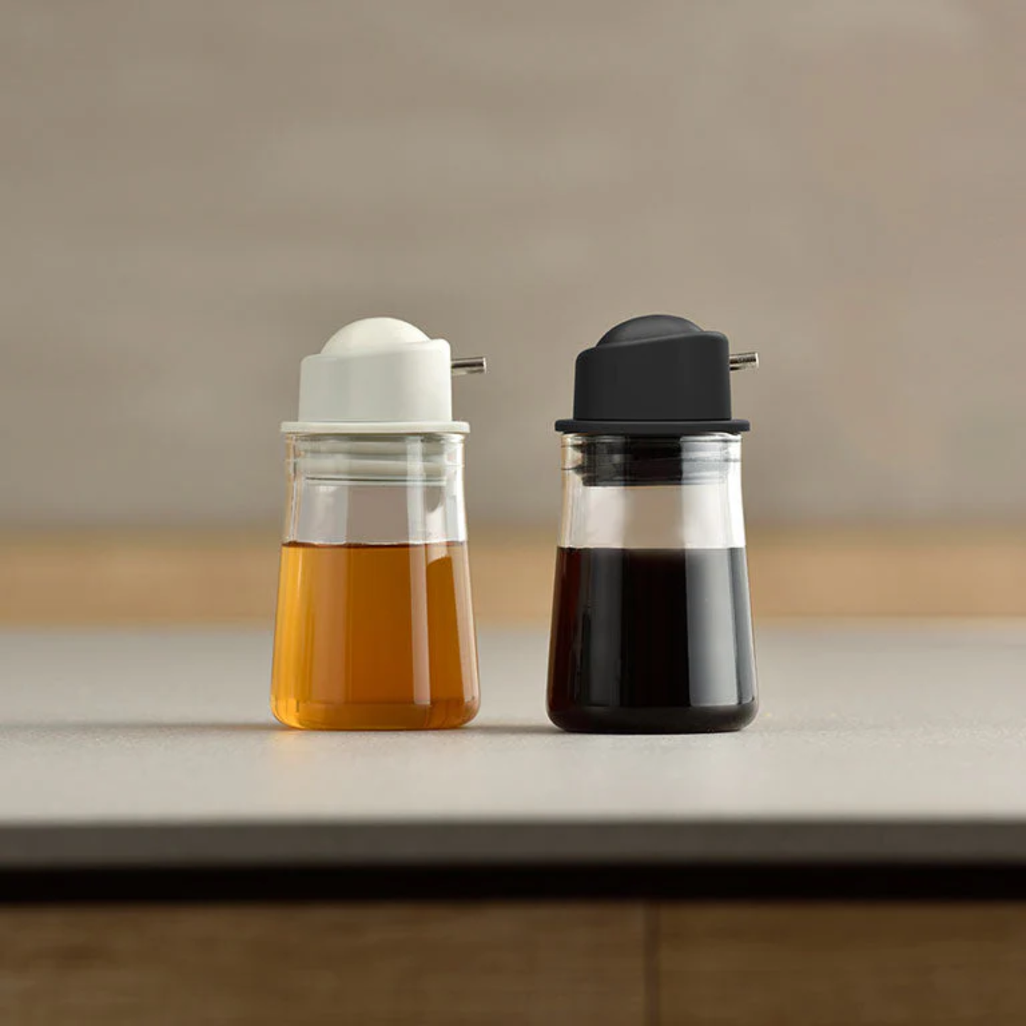 Showing gray and blackcolor of HARIO Soy Sauce Bottle -One Push-, refillable 80mL heatproof glass dispenser with stainless steel spout and silicone-sealed lid for easy, spill-free pouring.