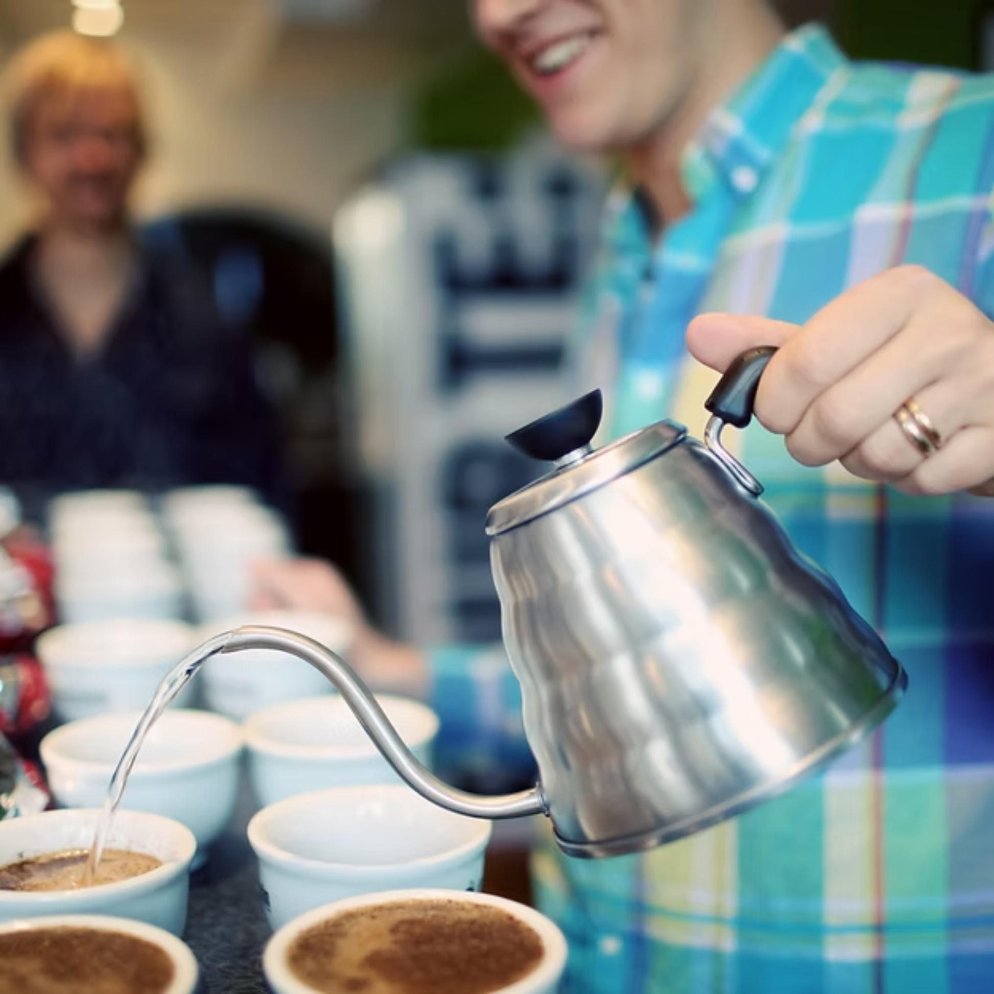 Shown on the table Hario V60 Drip Kettle - Coffee Kettle - Hairline Silver - Stainless Steel with Phenol Resin Handle - Slim spout design for precise pouring, 800mL capacity.