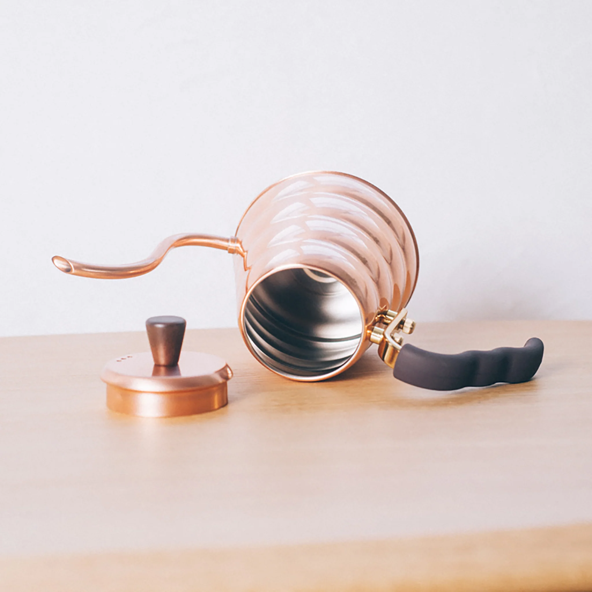 Open and showing what is inside of the Hario V60 Drip Kettle Buono 700ml Copper which includes Body of kettle and lid from copper, nickel and sealed with baked coating, lid knob from natural wood, handle from brass and handle cover from silicone rubber, luxurious of all kettles, iconic shape.