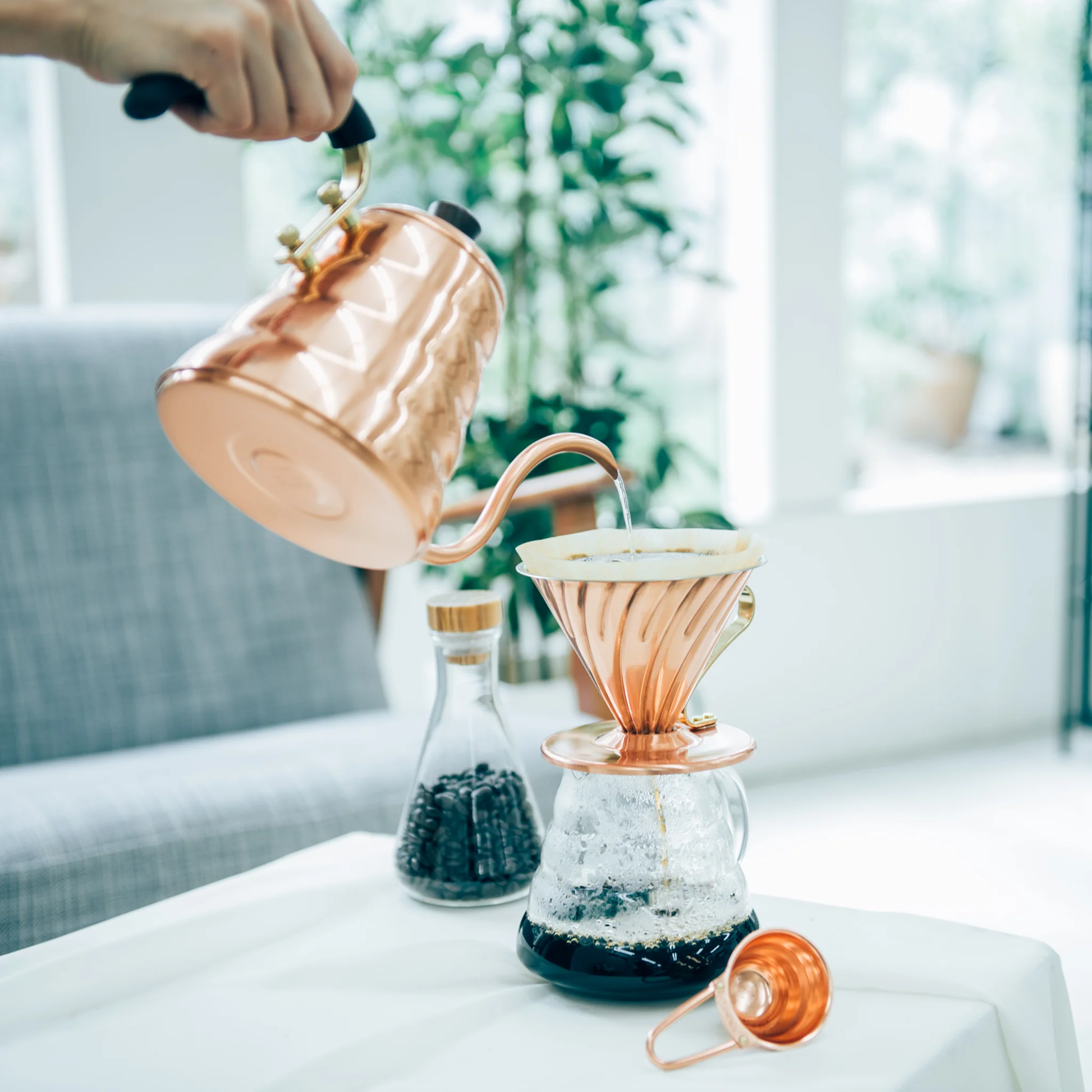 Pouring water to the coffee dripper using the Hario V60 Drip Kettle Buono 700ml Copper which includes Body of kettle and lid from copper, nickel and sealed with baked coating, lid knob from natural wood, handle from brass and handle cover from silicone rubber, luxurious of all kettles, iconic shape.