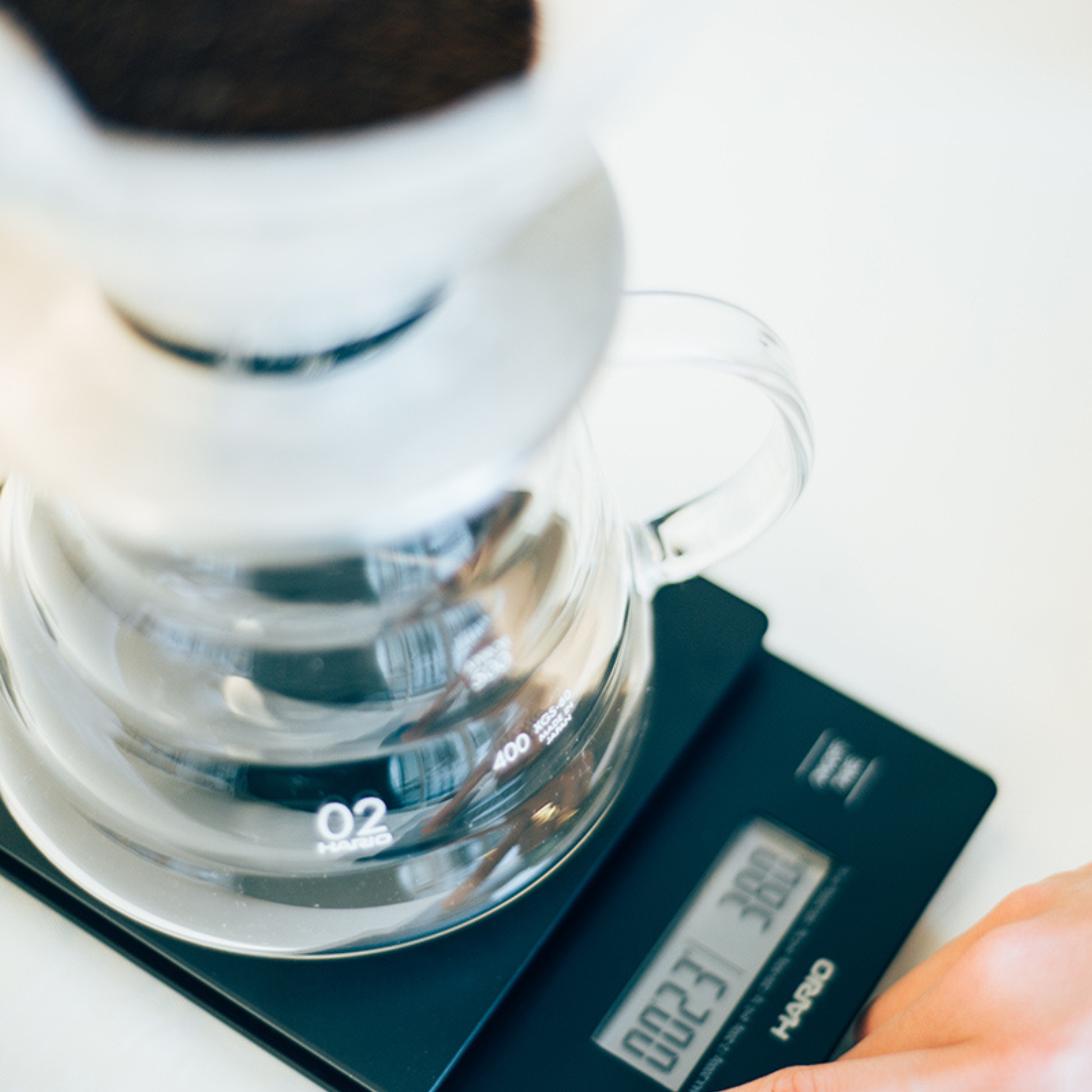Coffee with the dripper being weighed to the HARIO V60 Drip Scale Black ABS resin with built-in timer and precision measurement up to 2000 grams.