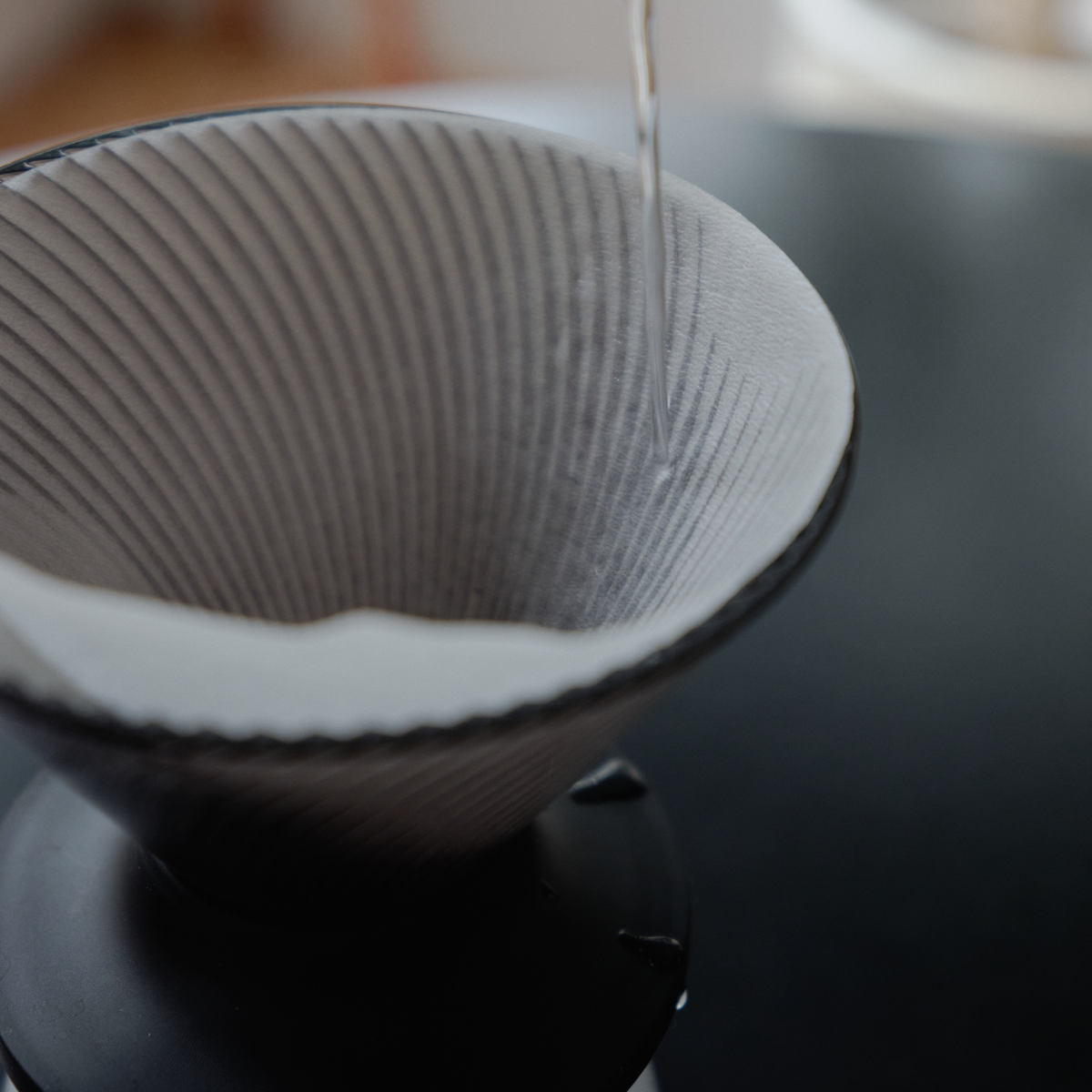 Putting hot water to the Hario V60 Neo Coffee Dripper 02 Black which is made from PCT resin and silicone rubber, with detachable base for hybrid brewing.