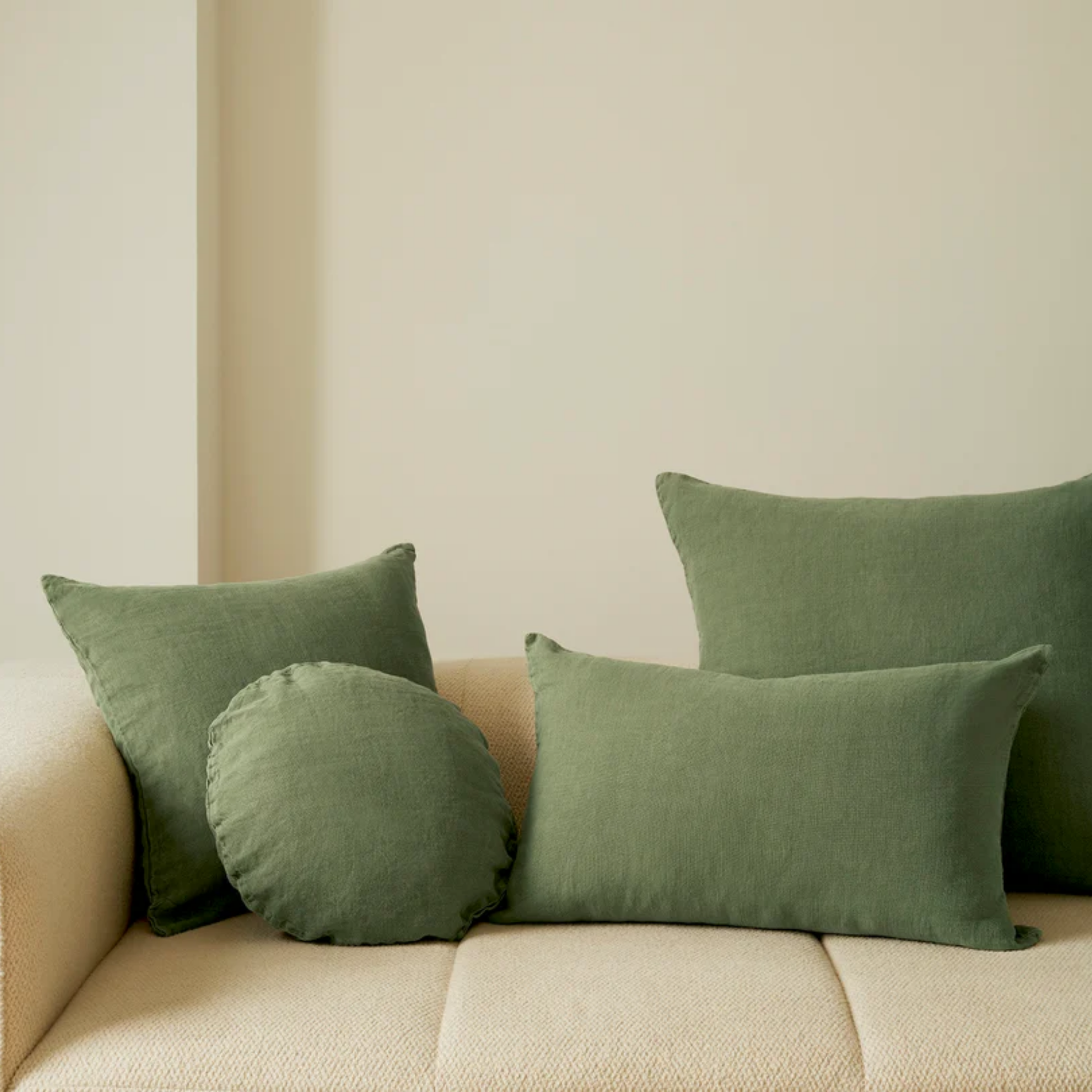 Hommey linen cushion moss on display on couch with linen moss range