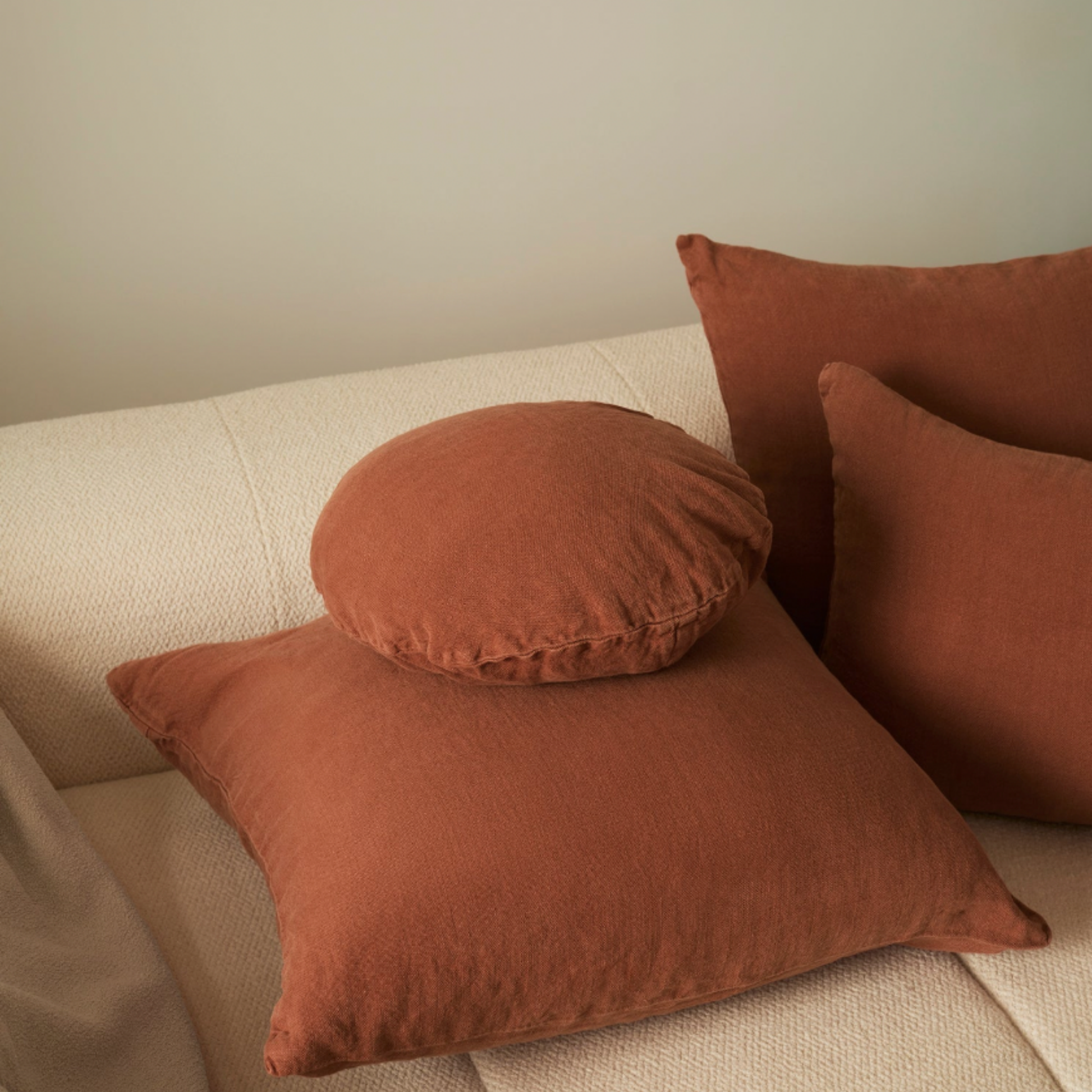 Hommey linen cushion rust on display on couch with linen rust range