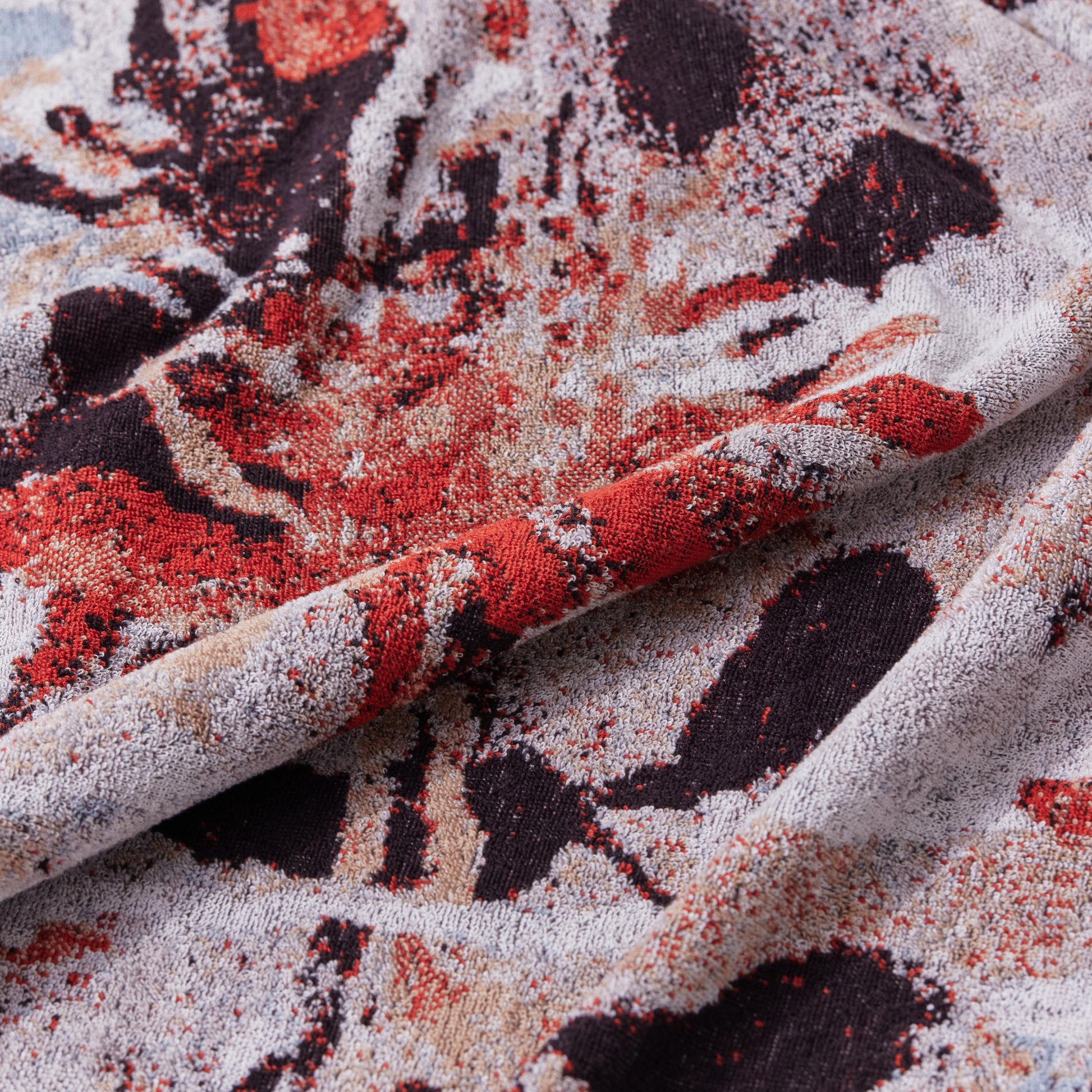 Close up on the floral design from Innate Ilford Guest Towel 30cm x 50cm guest towel featuring an iconic Waratah floral design inspired by the Australian bush, made from 100% OEKO-TEX® certified cotton, showcasing an absorbent six-colour jacquard weave with rich texture and weight, responsibly woven in Portugal for everyday premium use.