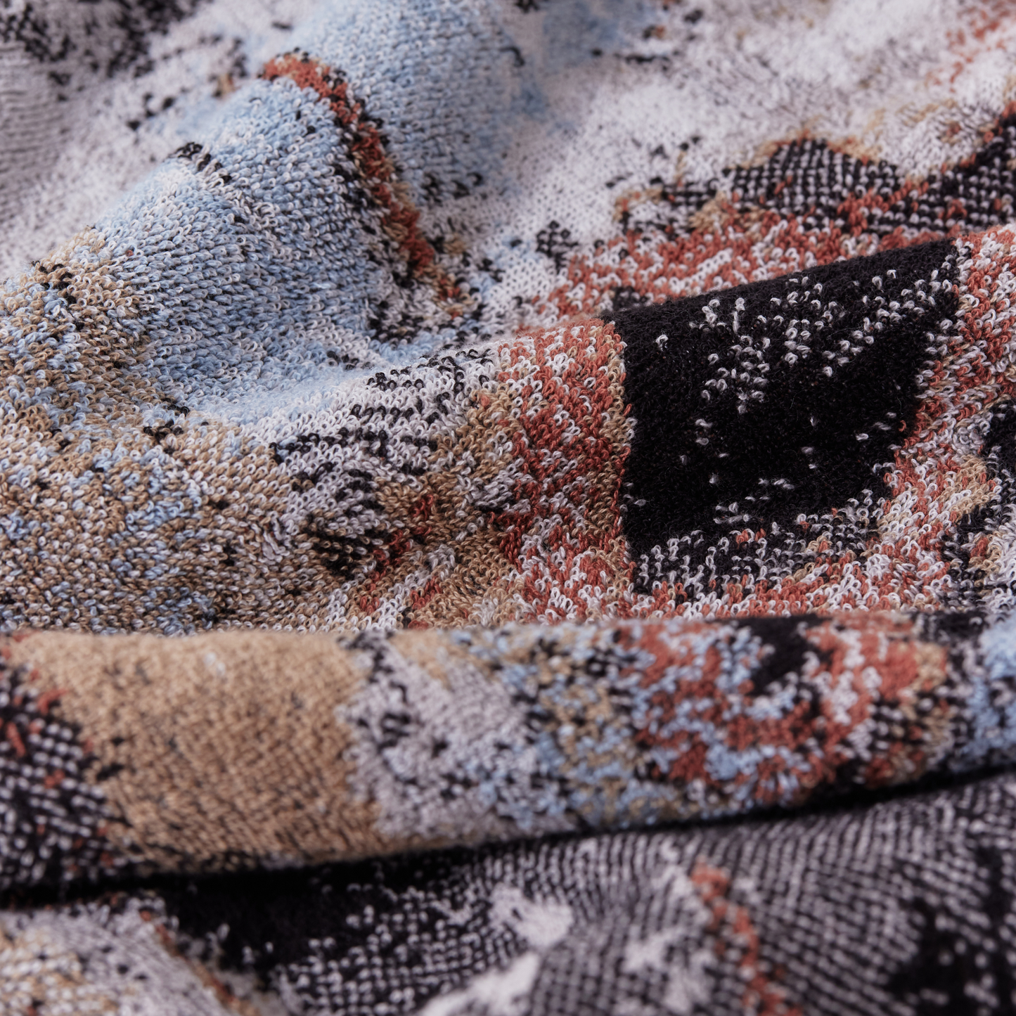 Close up on the design of the Innate NT Morning Bath Sheet 100cm x 150cm bath sheet in warm earthy tones inspired by Australia's Top End landscape, made from 100% OEKO-TEX® certified cotton, featuring an absorbent six-colour jacquard weave with rich texture and weight, responsibly woven in Portugal for everyday premium use.