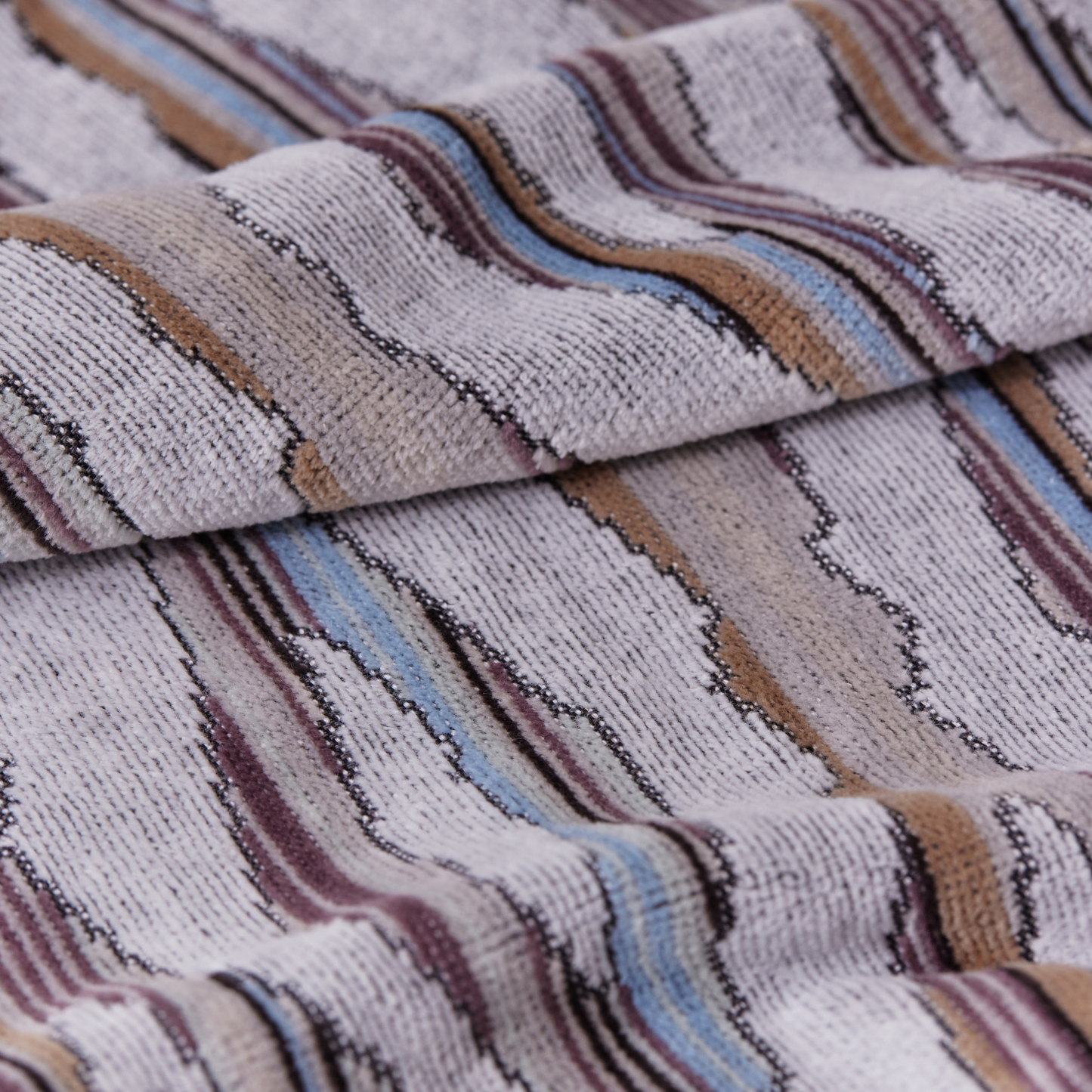 Close up on the design pattern from Ripple Light Hand Towel 40cm x 70cm - Misty Grey and White - 100% OEKO-TEX® Certified Cotton - Absorbent velour and terry jand towel with soft ripple breeze pattern, responsibly woven in Portugal for everyday use.