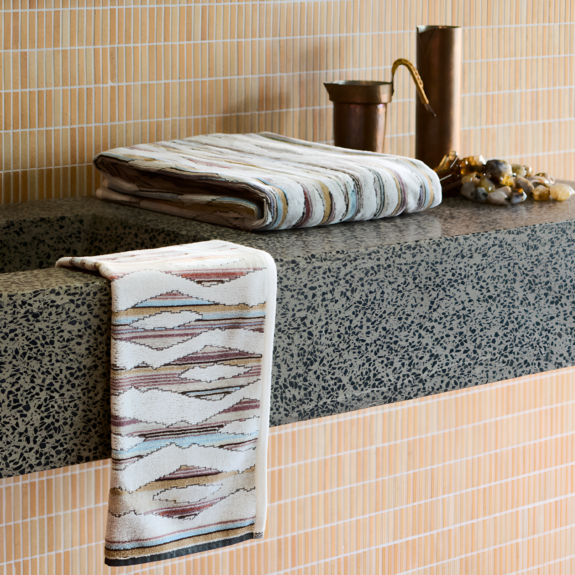 Shown folded on a sink, the Ripple Light Hand Towel 40cm x 70cm - Misty Grey and White - 100% OEKO-TEX® Certified Cotton - Absorbent velour and terry jand towel with soft ripple breeze pattern, responsibly woven in Portugal for everyday use.