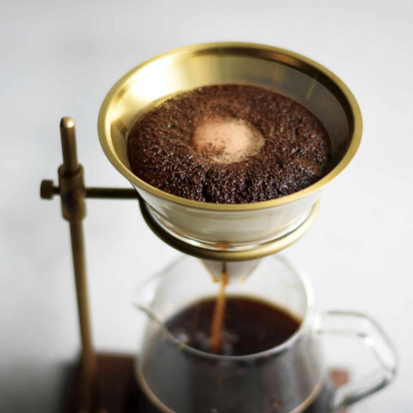Kinto Brass Brewer Stand Set 700ml on display in use with coffee filtering through the filter
