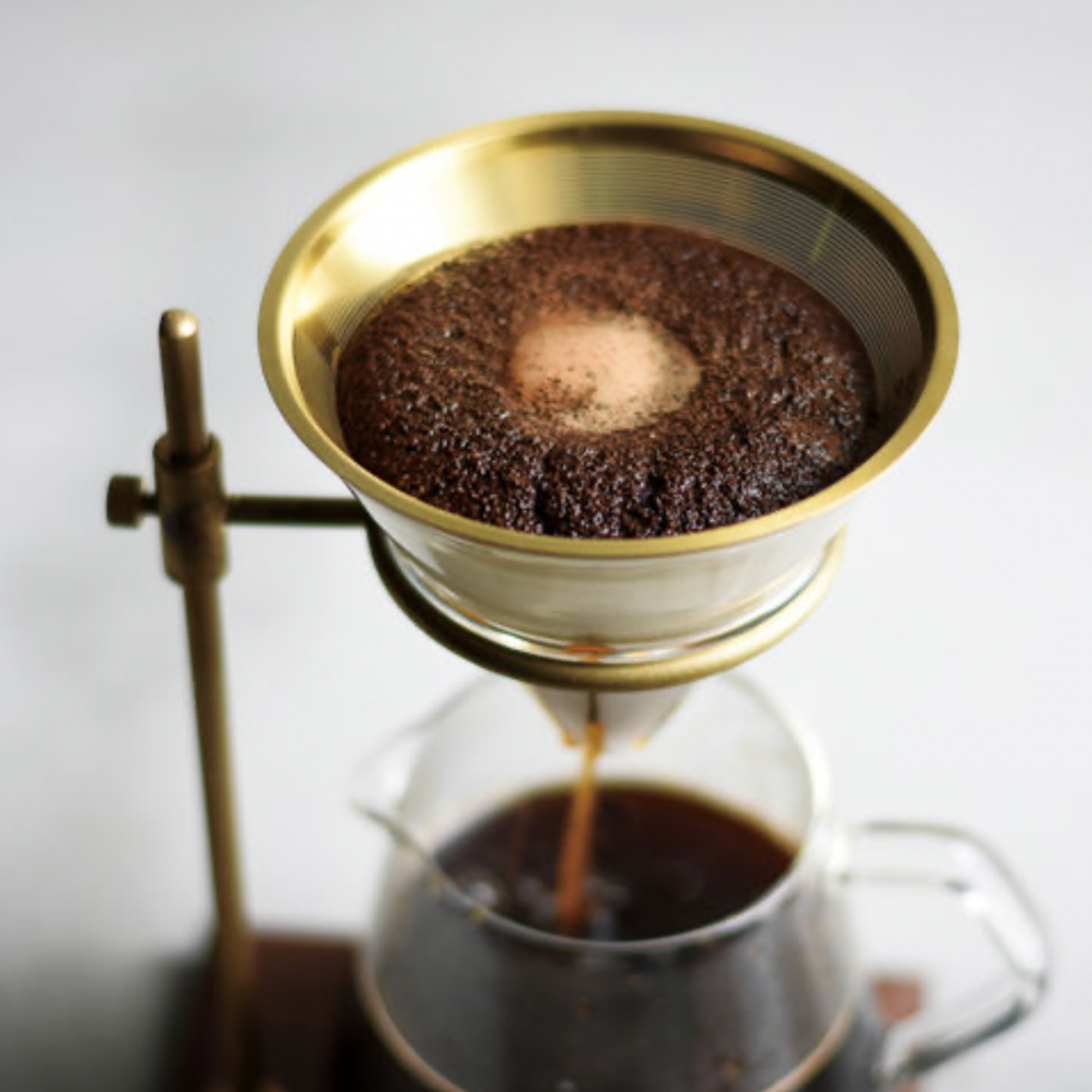 Kinto Brass Brewer Stand Set 700ml on display in use with coffee filtering through the filter