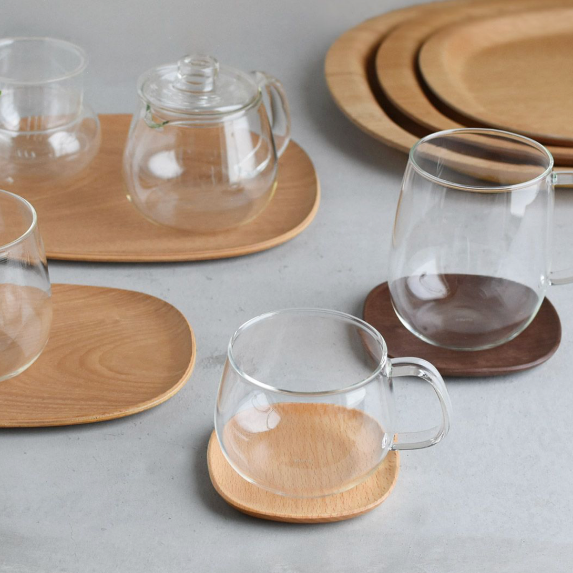 Stylish glass Kinto Unitea Cup 350ml on display with various Kinto Unitea cups on wooden boards 