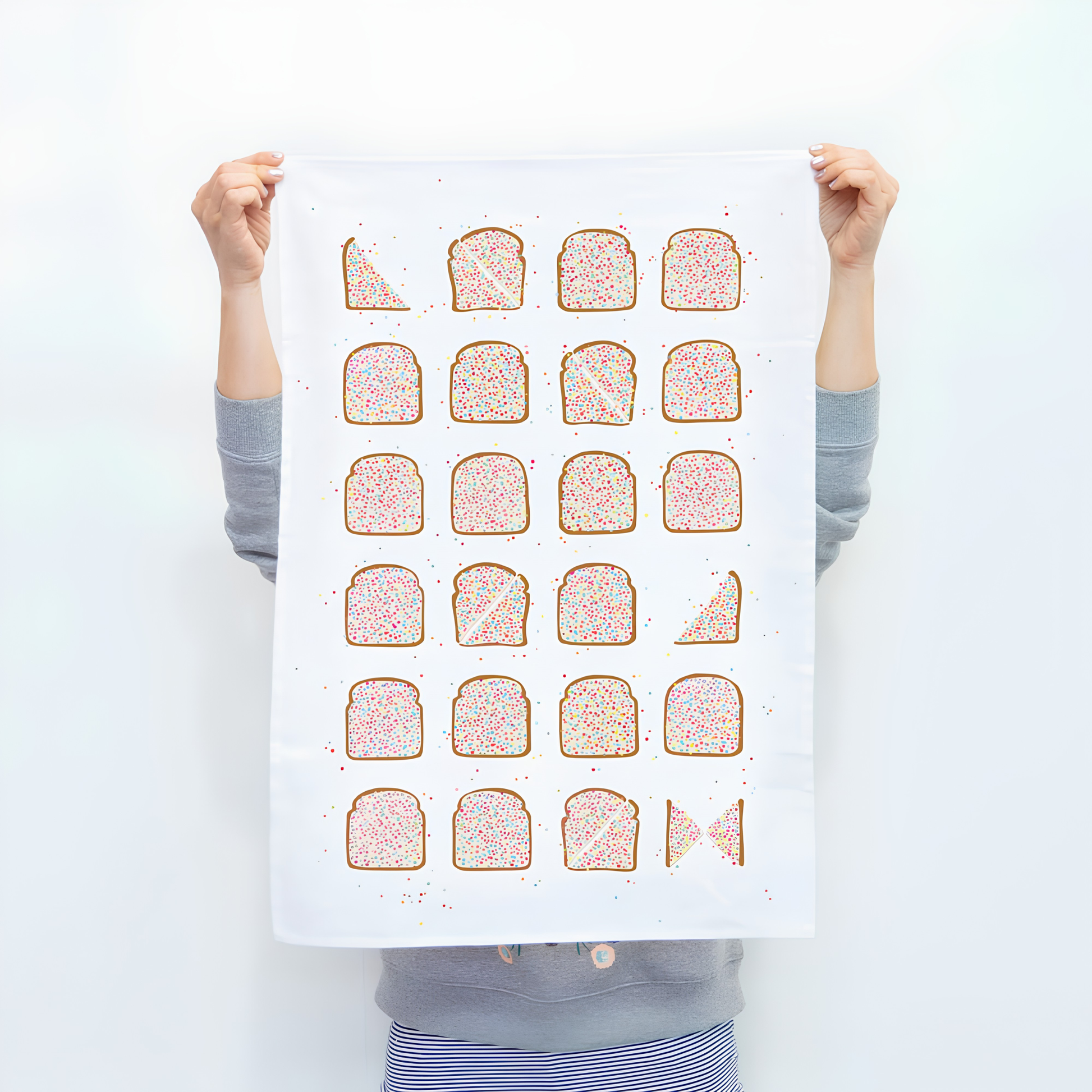 Front of the Make Me Iconic Tea Towel Fairy Bread held and raised by a girl. one of Australia's most iconic treats, these slices of bread with butter and rainbow sprinkles put on a tea towel. Made from high quality, absorbent fabric.