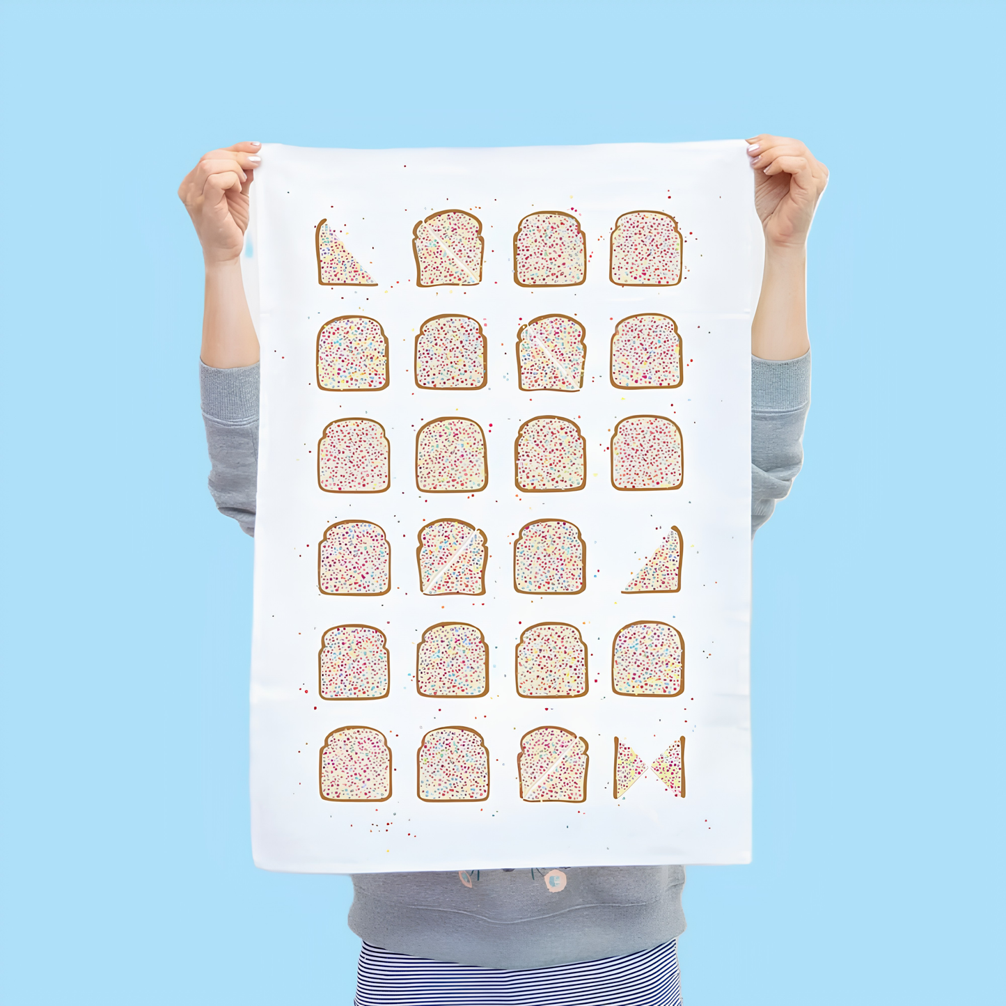 Another image of the front of Make Me Iconic Tea Towel Fairy Bread held and raised by a girl. one of Australia's most iconic treats, these slices of bread with butter and rainbow sprinkles put on a tea towel. Made from high quality, absorbent fabric.