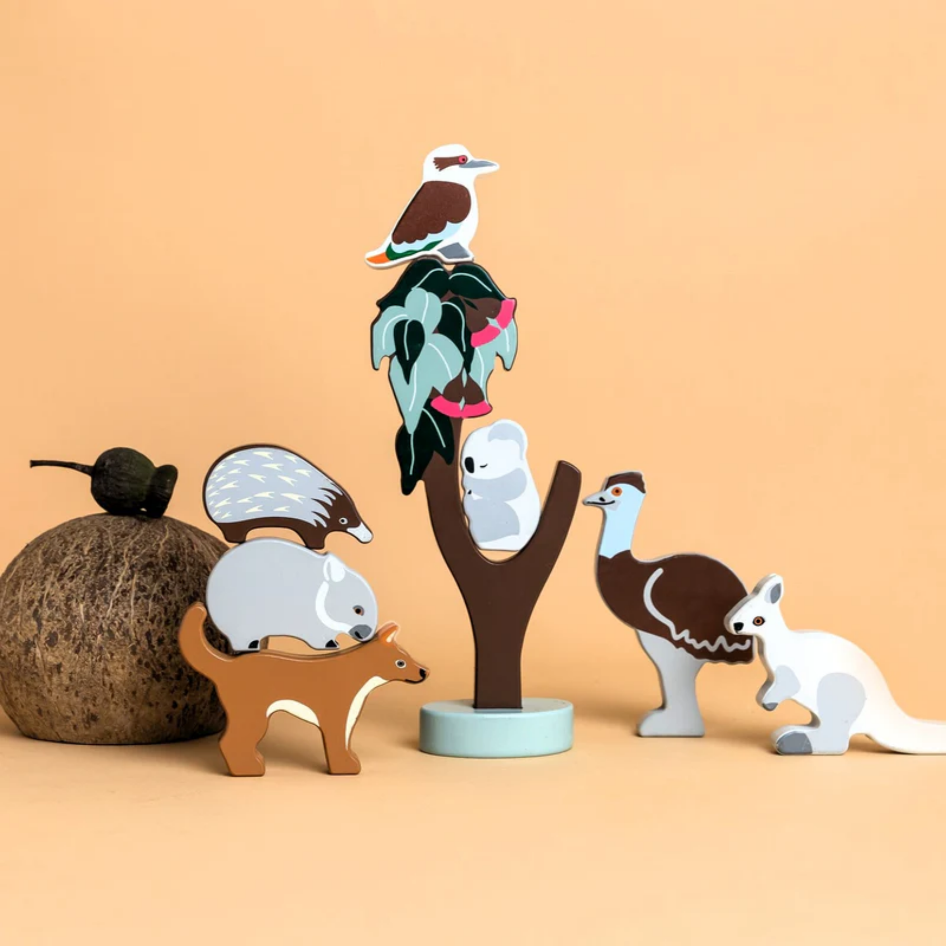 Displayed with a solid bright background Make Me Iconic wooden Australian animal toy set featuring eight native animals and a gum tree, crafted from non-toxic wood with eco packaging - includes kangaroo, koala, wombat, platypus, emu, echidna, dingo, and kookaburra for open-ended play celebrating Aussie wildlife and culture.