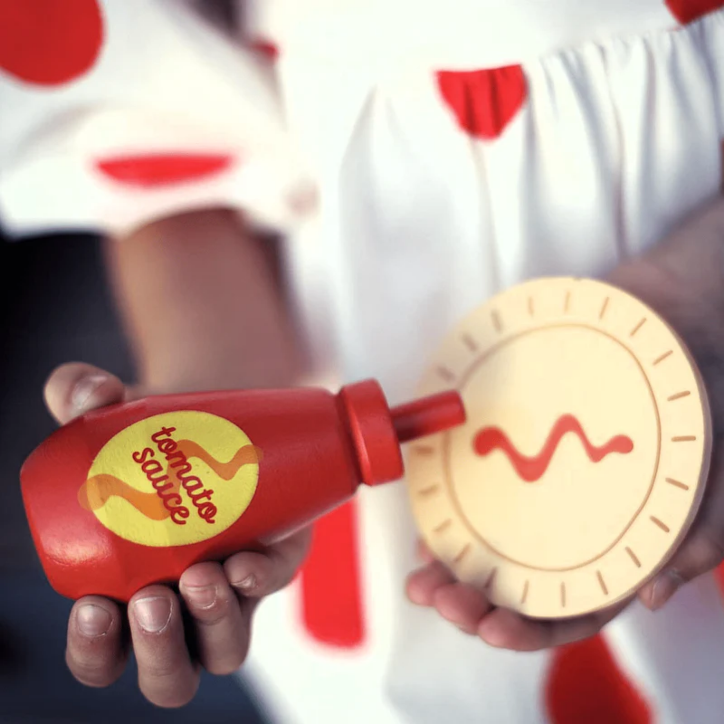 Little girl playing the meat pie and sauce toy from Make Me Iconic wooden Aussie food toy set featuring 38 handcrafted pieces including classic favourites like sausage sandwich, burger, lamington, meat pie, fairy bread, and chips, made from non-toxic wood with felt and Velcro parts - perfect for pretend barbecues, kitchen play, and creative Aussie-themed fun.