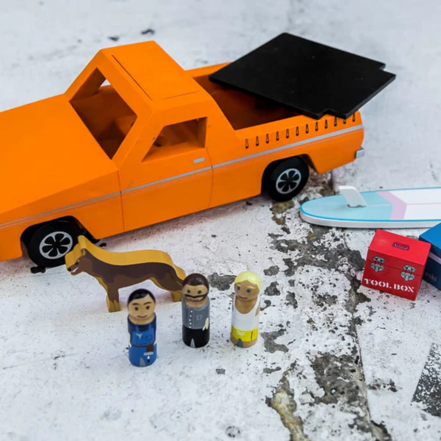 Make Me Iconic wooden blue Ute toy set with rolling wheels, lift-off roof, three wooden passengers, a Kelpie dog, surfboard, esky, and toolbox - a nostalgic Aussie-inspired playset designed in Australia to spark creativity and hands-on imaginative fun for children aged 3 and up.