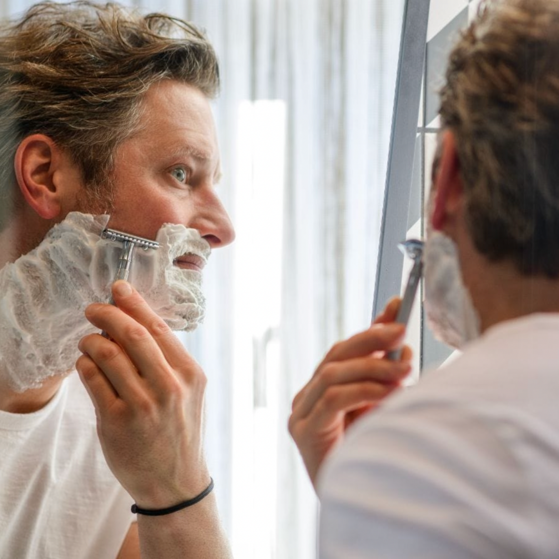 Man shaving beard in mirror with Stylish Merkur Safety Razor 23C Long Handle Chrome