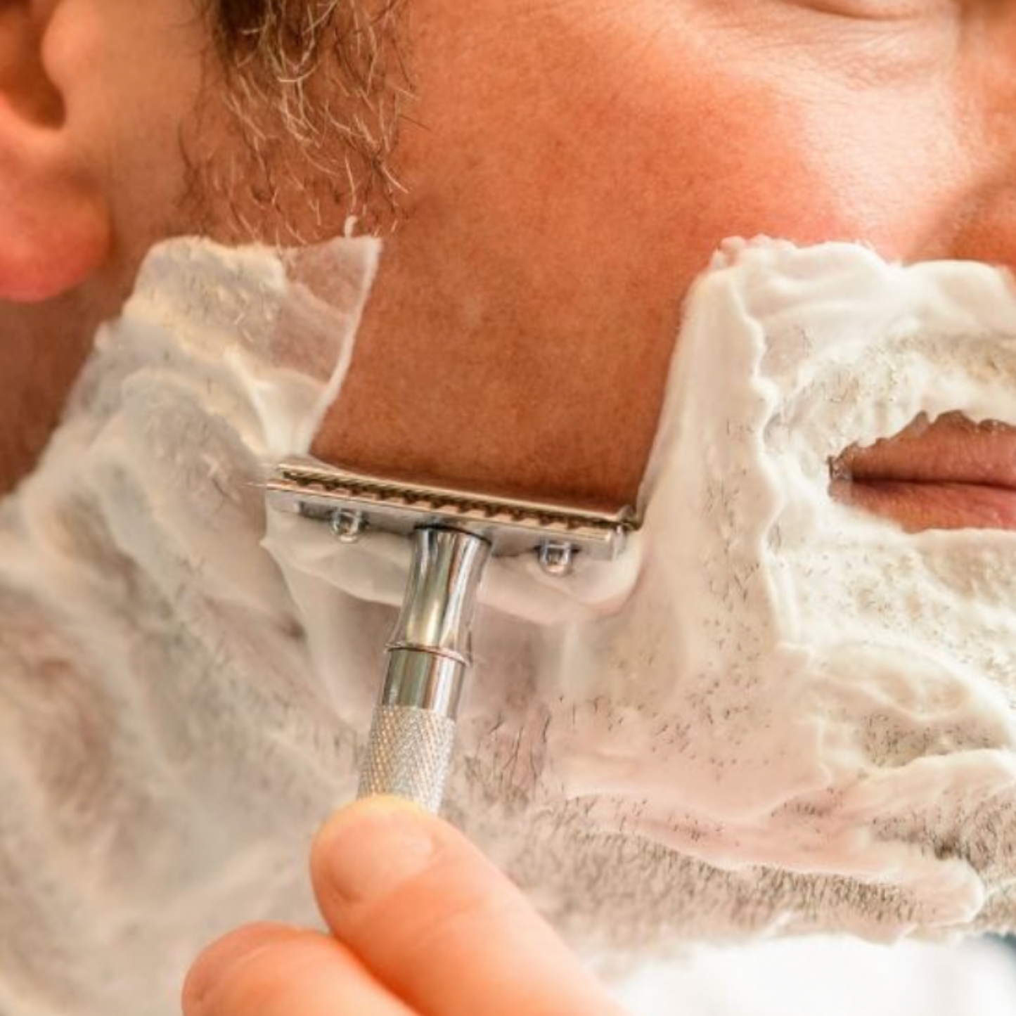 Close up of man shaving beard eith Stylish Merkur Safety Razor 23C Long Handle Chrome 