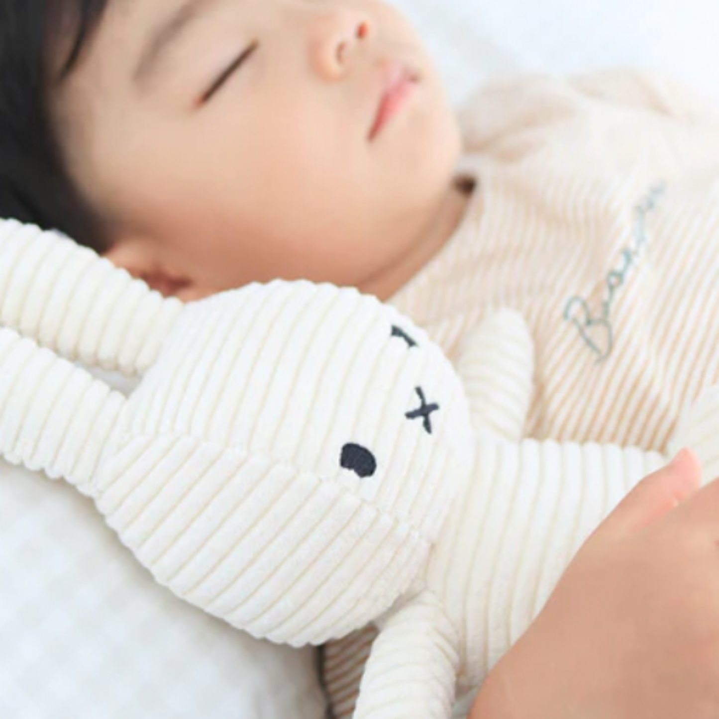Child cuddling Sitting Miffy 23cm offwhite corduroy in bed asleep