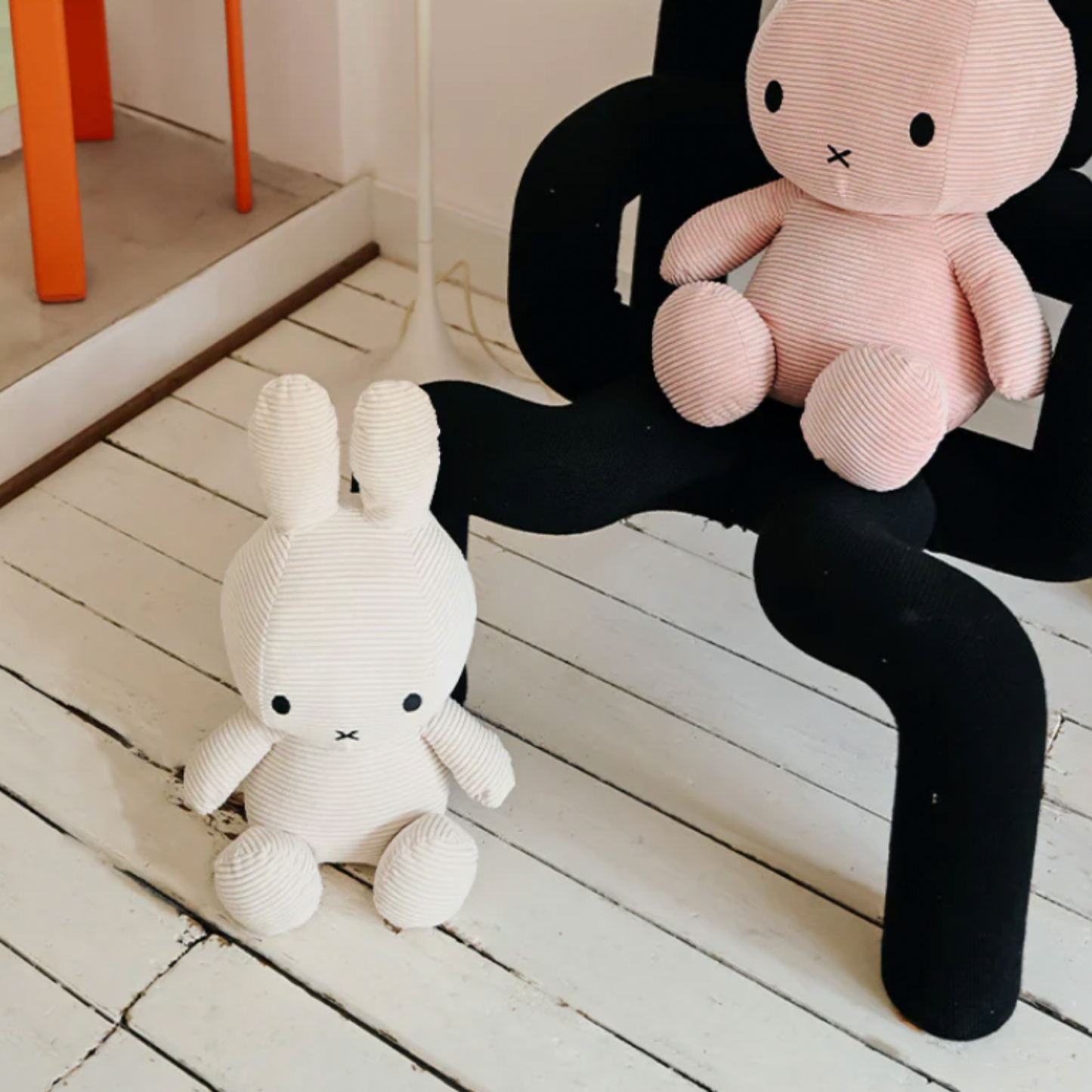 Sitting Miffy 50cm off white on white floor boards next to chair and large pik sitting miffy