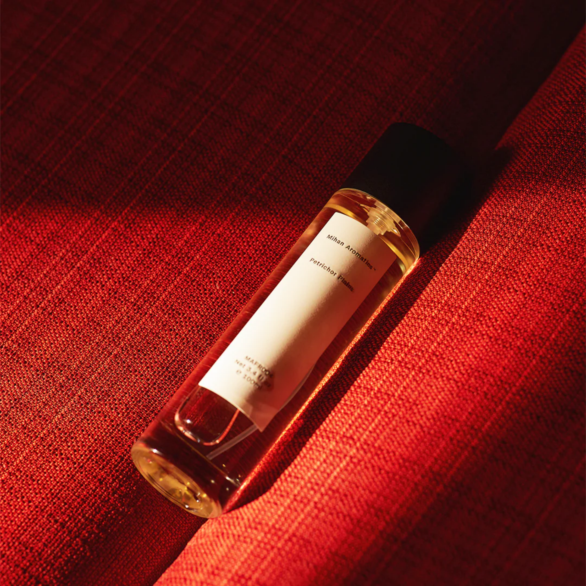 Mihan Aromatics 100ml Petrichor Plains on red couch in sunlight