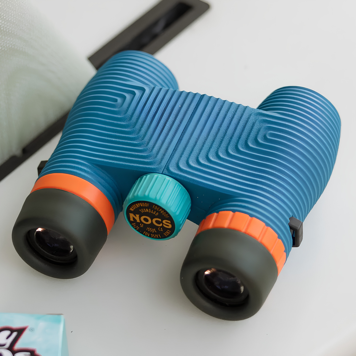 Top view of the Nocs Provisions Binocular Standard Issue 8X25 Cobalt Blue that has multi-coated lenses and premium BaK4 prisms, waterproof, fogproof and compact.