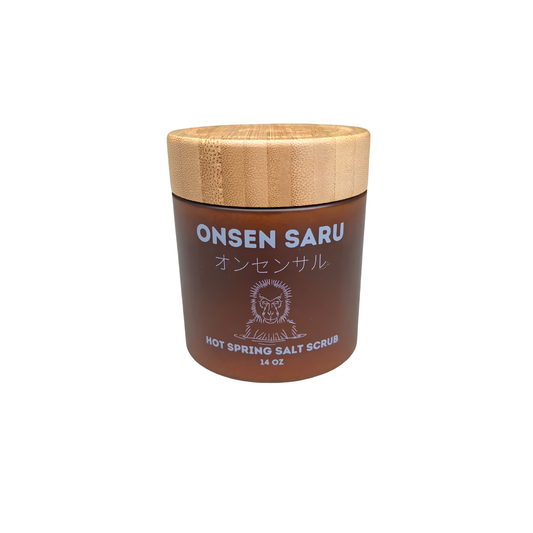 Front view of the Onsen Saru Hot Spring Salt Scrub 14oz jar, frosted amber plastic, engraved bamboo lid and cardboard box
