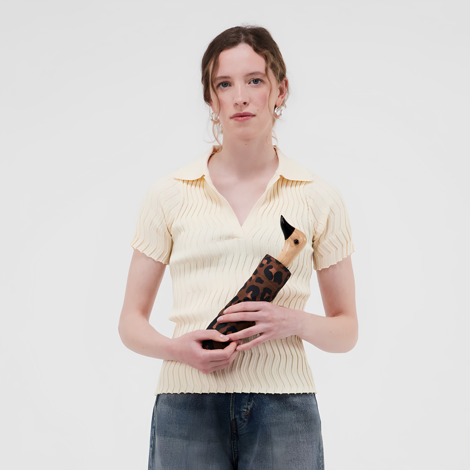 A woman holding the kept Original Duckhead Duck Umbrella Compact Leopard timeless animal print design from sustainable materials.