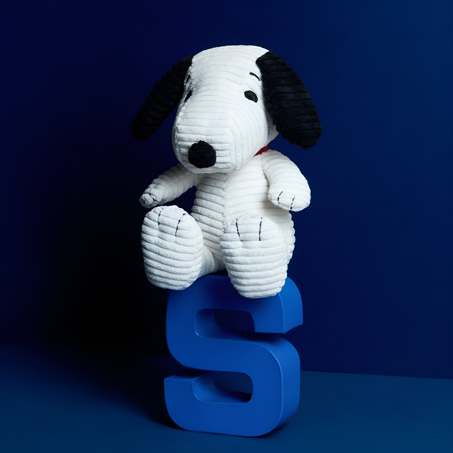 On a blue block letter S, the Peanuts Snoopy Corduroy 19cm Cream, made from best corduroy, hand made and contains 100% recycled polyester, the world famous dog Snoopy can be paired with his little yellow friend Woodstuck.