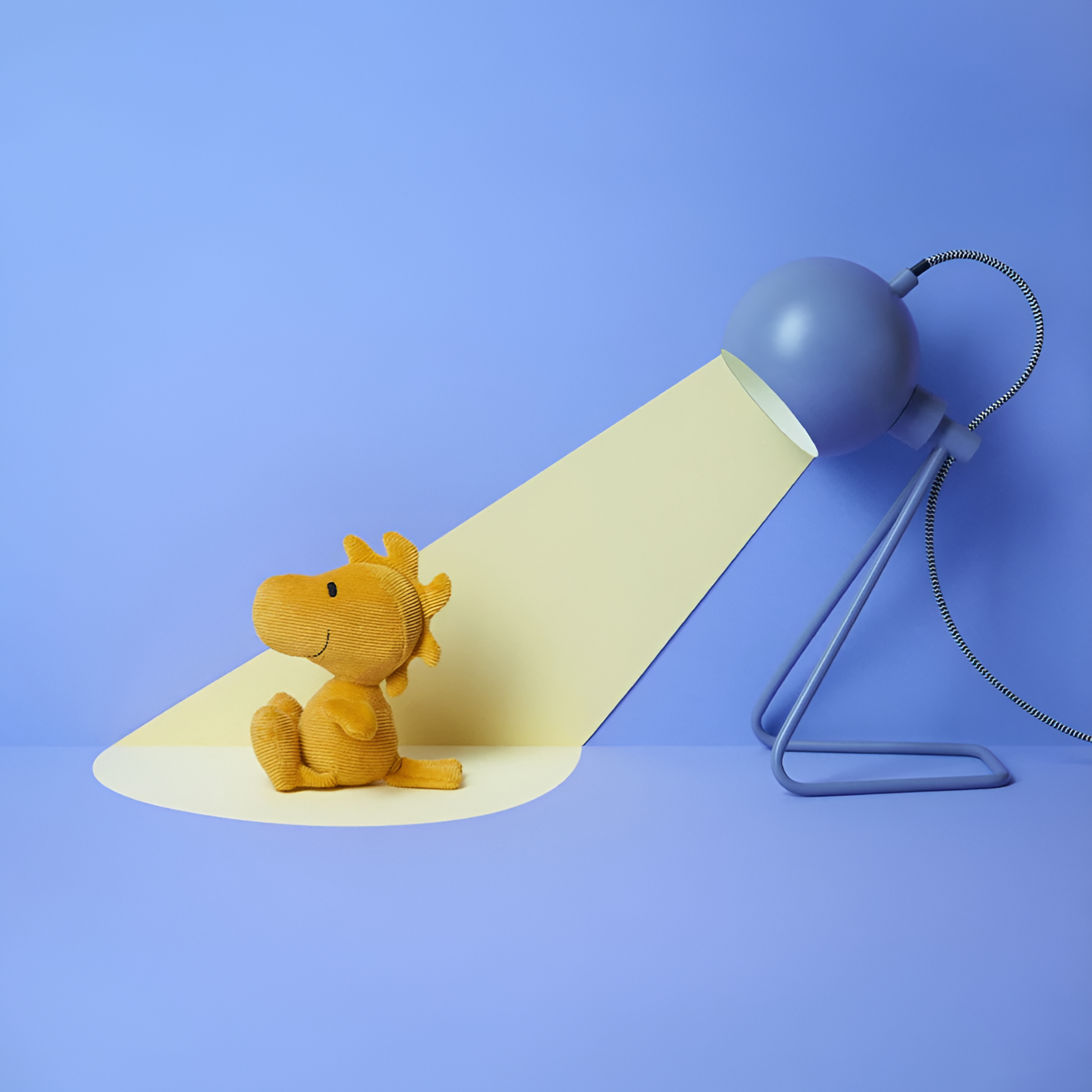 Pointed by a lamp and side view of the Peanuts Woodstock Corduroy 15cm Yellow, made from Polyester Needle cord and filled with 100% recycled polyester, Snoopy's yellow intellectual friend.