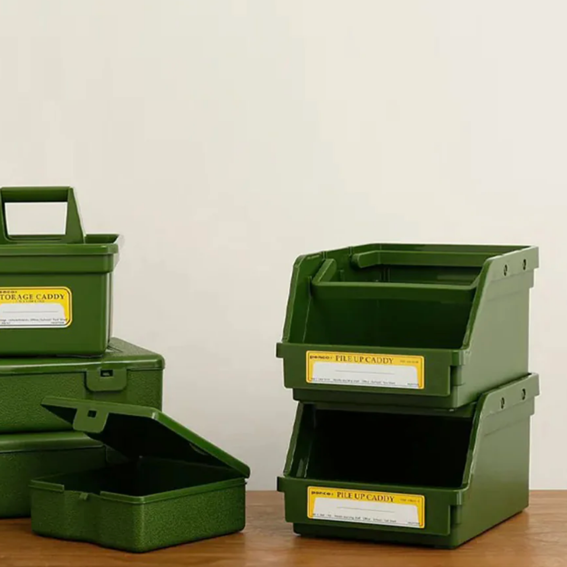 Assorted Penco green pile up caddys on wooden table