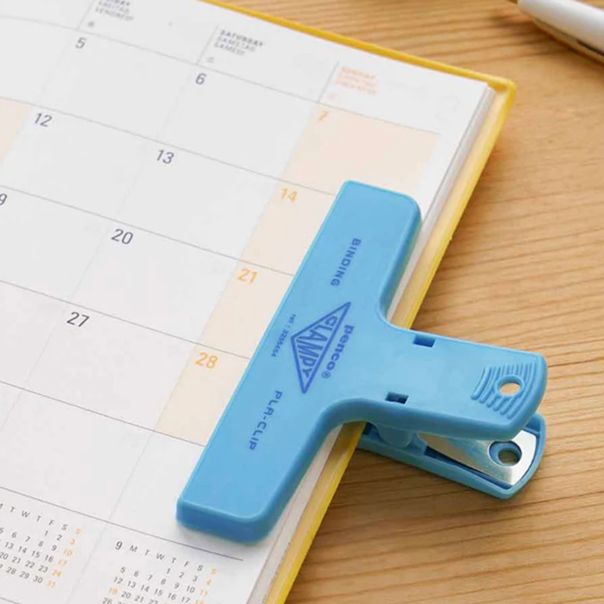Penco plastic light blue clip on edge of diary holding book open