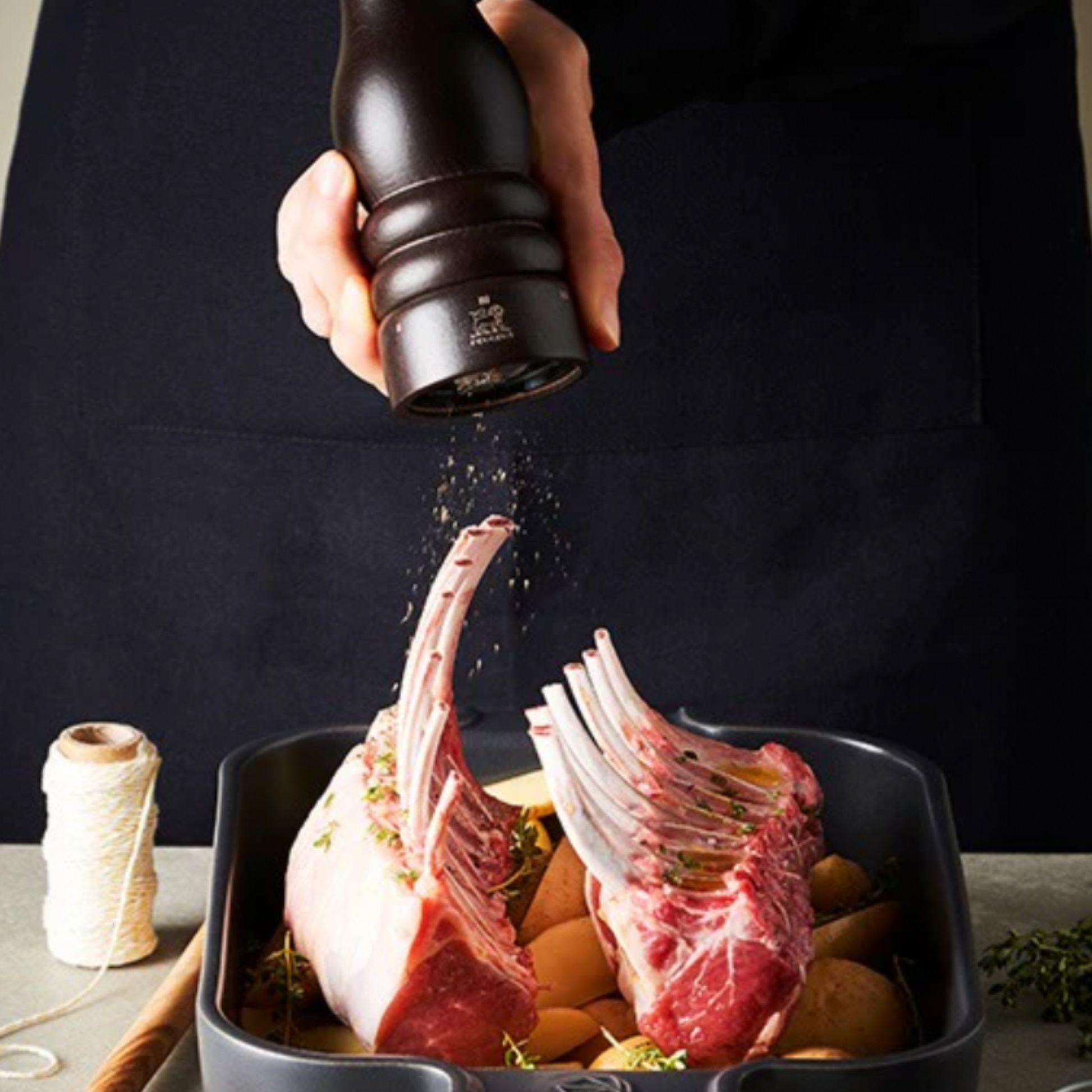 Peugeot Paris uSelect Pepper Mill 18cm Chocolate being used to season a rack of lamb on kitchen bench