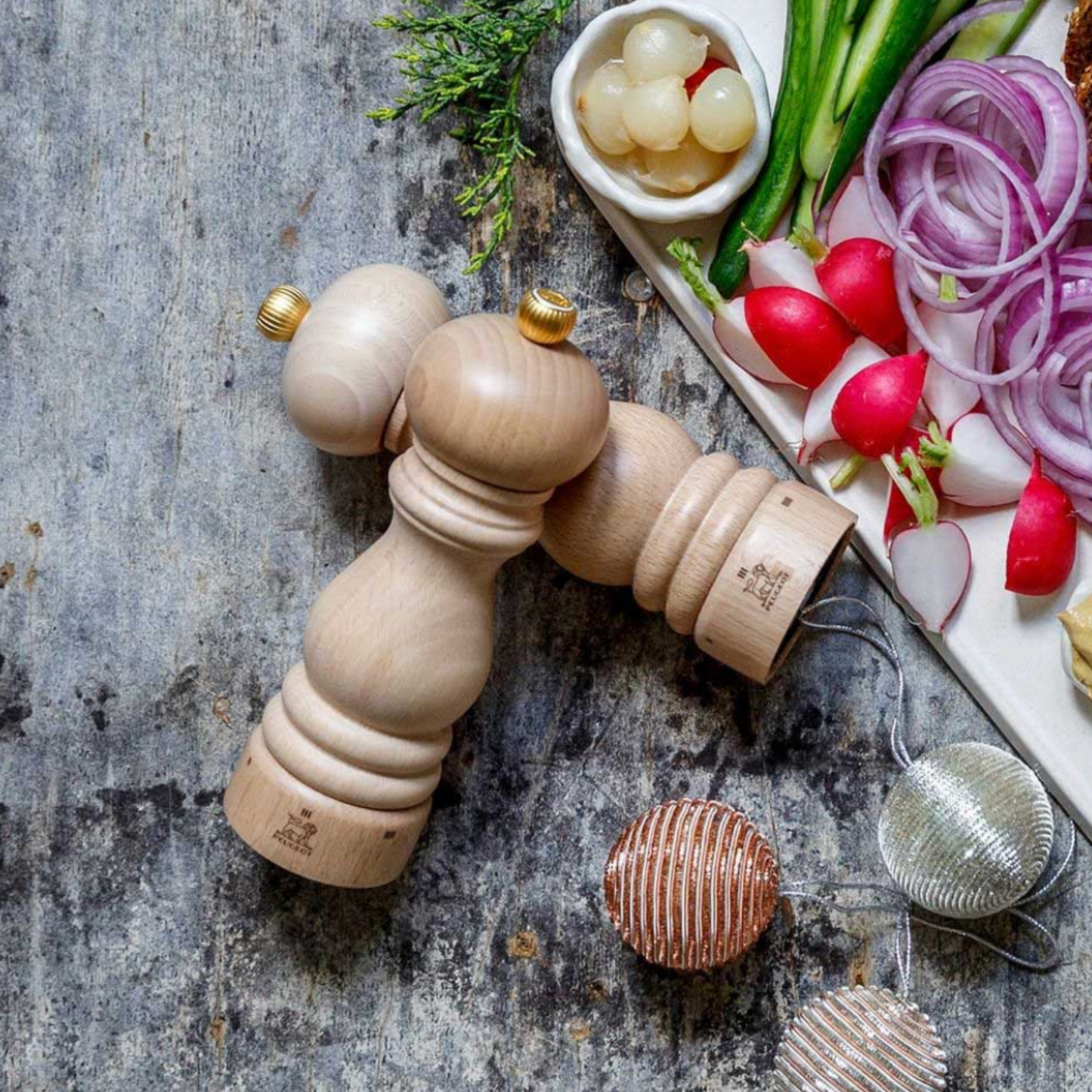 Pair of Peugeot Paris uSelect Pepper Mill 18cm Natural on Kitchen bench with assorted vegatbles on platter