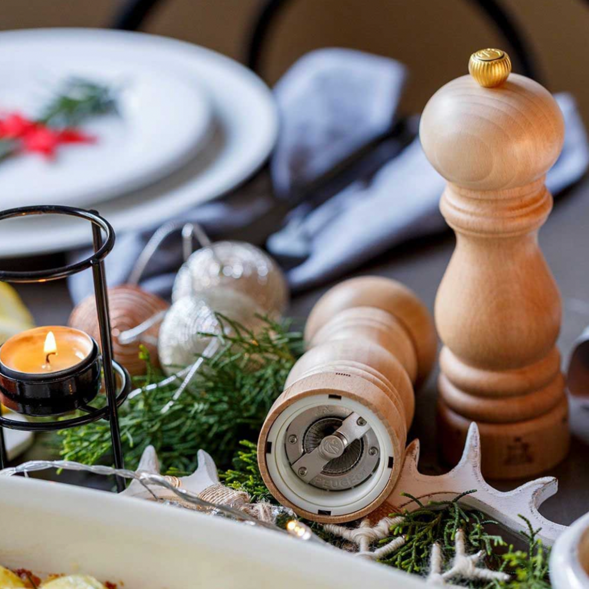 Pair of Peugeot Paris uSelect Pepper Mill 18cm Natural on dining table with christmas decorations