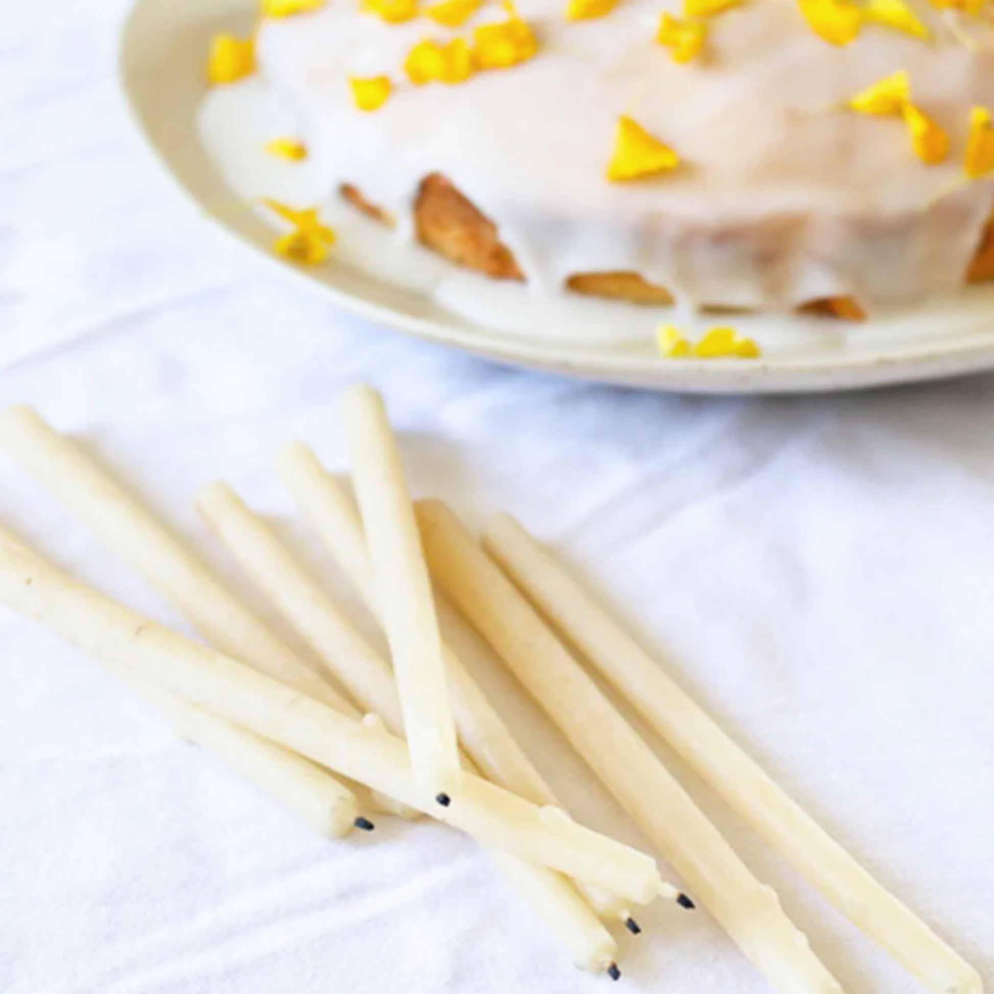 Queen Bee birthday candles next to cake on linen set table