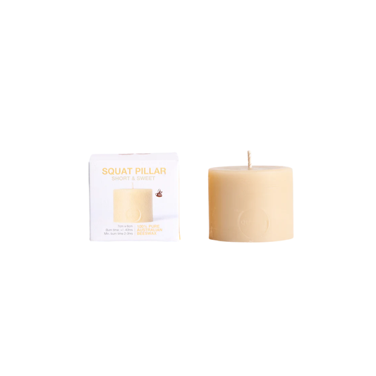 Queen Bee beeswax pillar squat candle next to packaging box