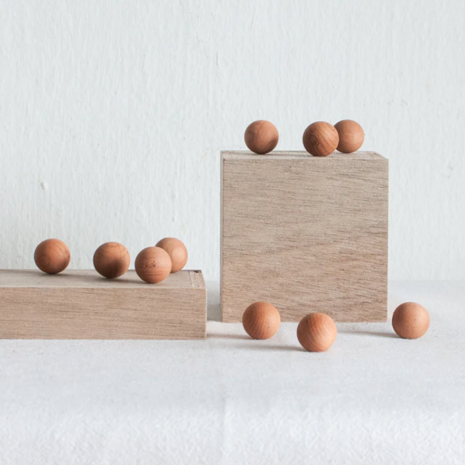 Redecker cedar balls displayed on wooden blocks 