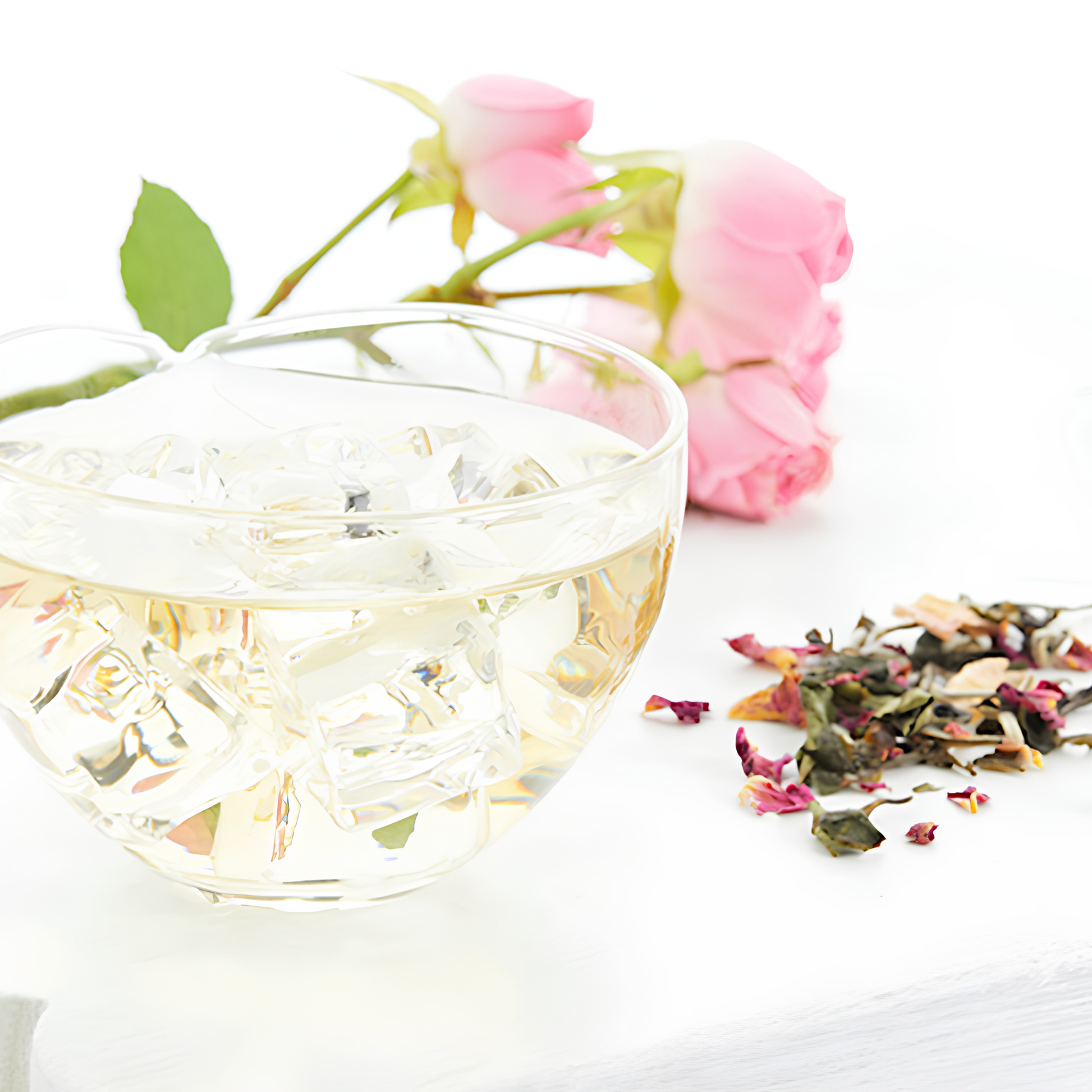 Showing a bowl of water and ice cubes with the Ripple Effect Tea Co Loose Leaf Tea 30g Moonlight Rose on the the table surface, dry leaves which are white on the side and shadowy black on the other