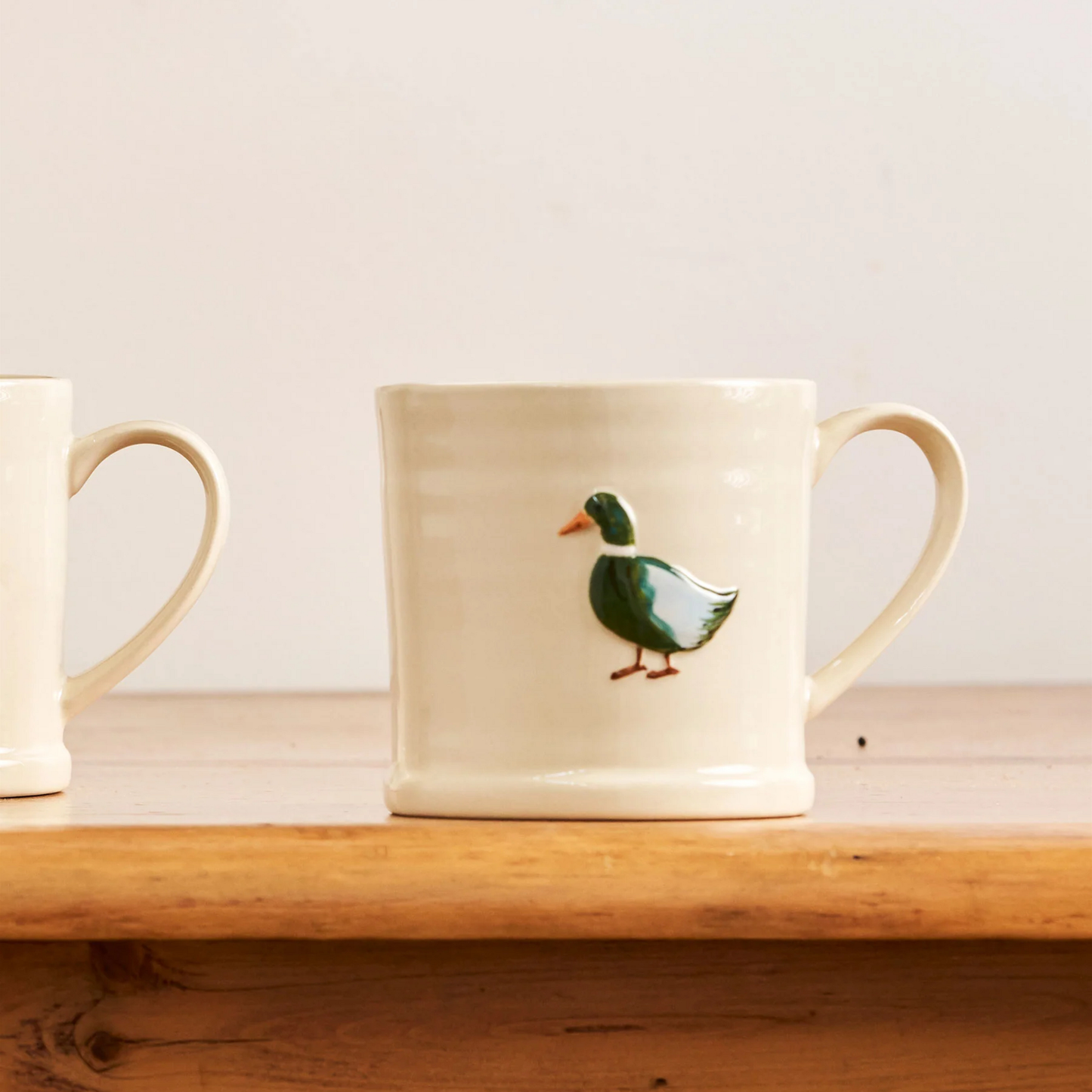 On a table surface, the Robert Gordon Favourite Things Mug Large with a quirky hand painted character design Duck.
