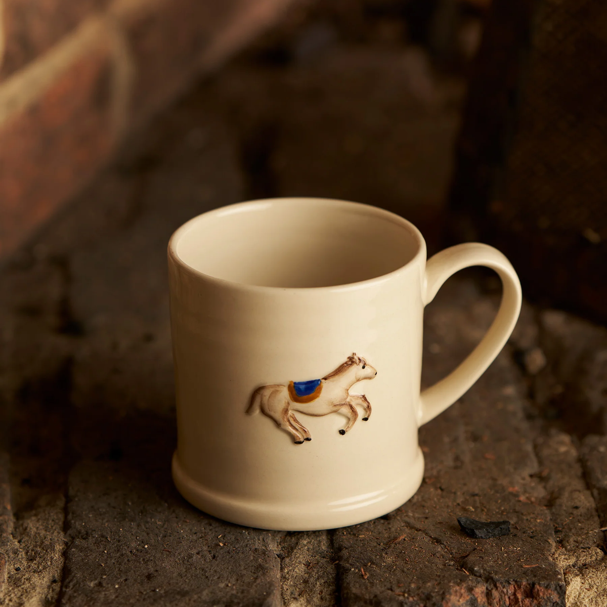 Front view of the Robert Gordon Favourite Things Mug Large on a brick, made from stoneware with Horse motif painted by hand with 310ml capacity.
