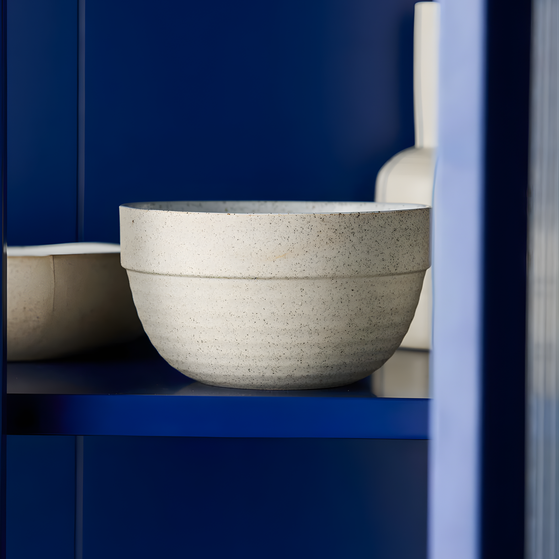 Seen on a kitchen cabinet, the Robert Gordon Garden To Table Pudding Bowl 1L 16x11cm Off-white Earthly clay body with light organic glaze and dark speckles, hand crafted made from stoneware, microwave and dishwasher safe, designed in Australia, made in China.