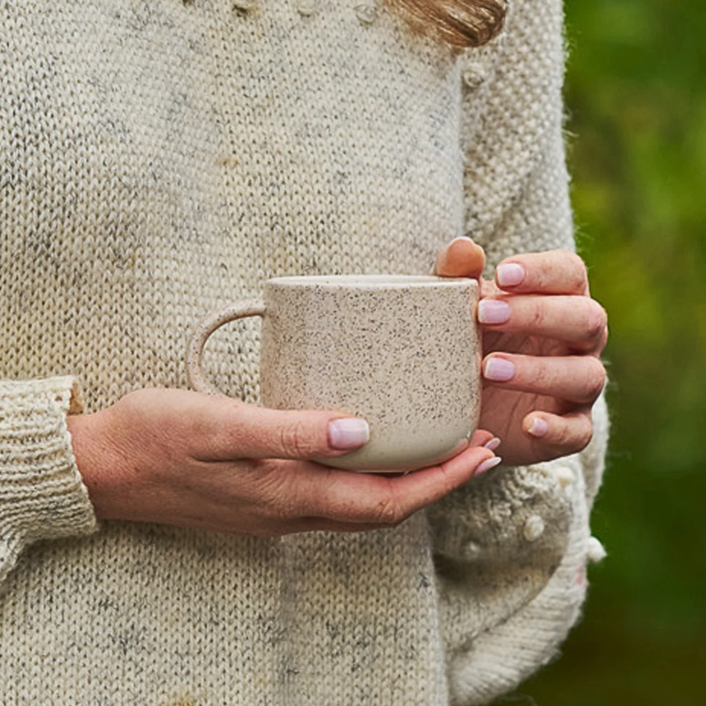 On outdoor, a woman holding the Robert Gordon My Mug (set of 4) Celestial 350ml capacity Off-white featuring delicate speckling giving charm and character, made from durable stoneware, microwave and dishwasher safe, designed in Australia, made in China.