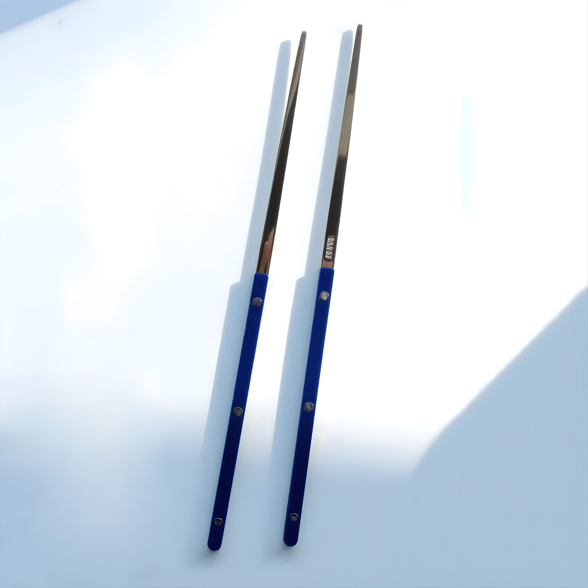 On a surface, the Sabre Bistrot Cutlery Chopsticks 23cm (pair) Navy Blue, which is made from Inox 18/10 - Manche nylon, not dishwasher safe and not suitable in microwave oven, ergonomic design for comfortable grip, ideal for enjoying dishes such as sushi or noodles.
