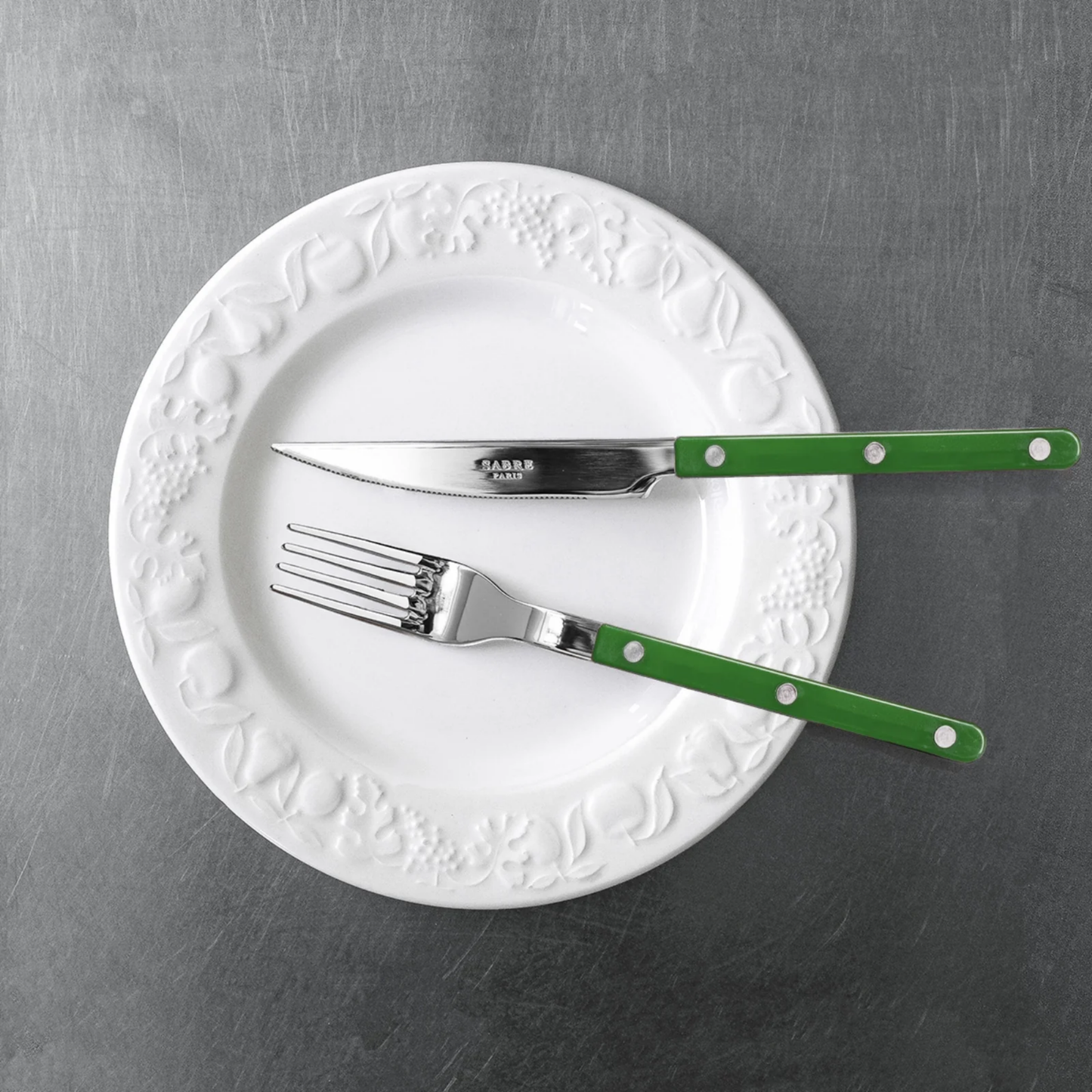 Knife and fork on a plate from Sabre Bistrot Cutlery Dark Green 24 Piece Set