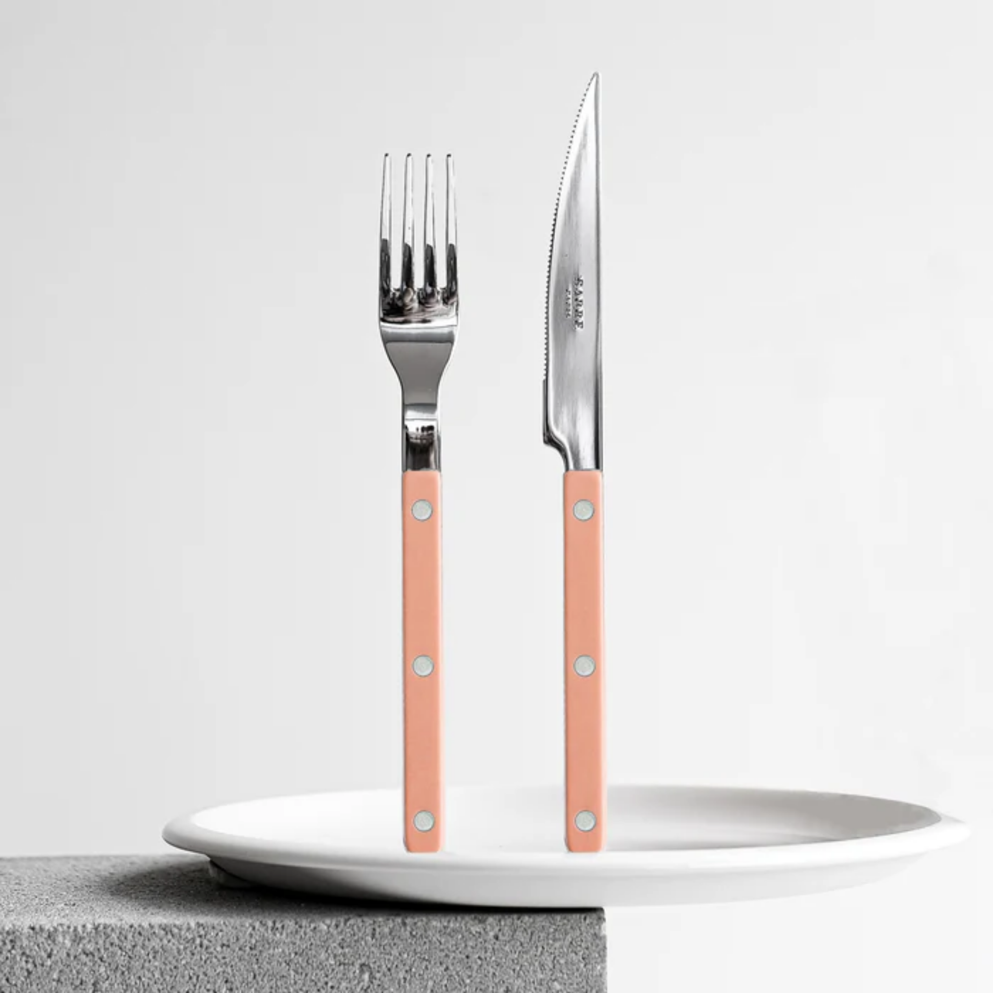 Standing on a plate Sabre Paris Bistrot Dinner Knife - 24cm stainless steel knife with durable nylon handle and visible rivets. Elegant, dishwasher-safe cutlery inspired by classic bistro style, perfect for everyday meals or stylish table settings.