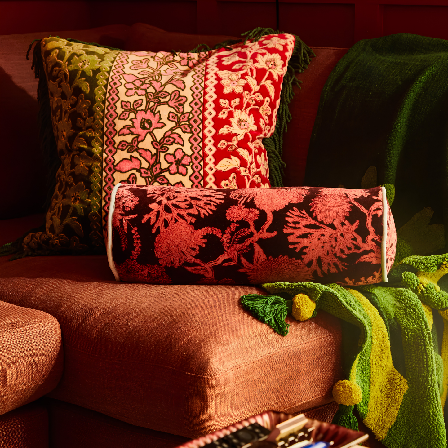 Sage & Clare Cushion Bolster Velvet Delphine that has a soft touch, piping edges and high quality insert lying on a couch.