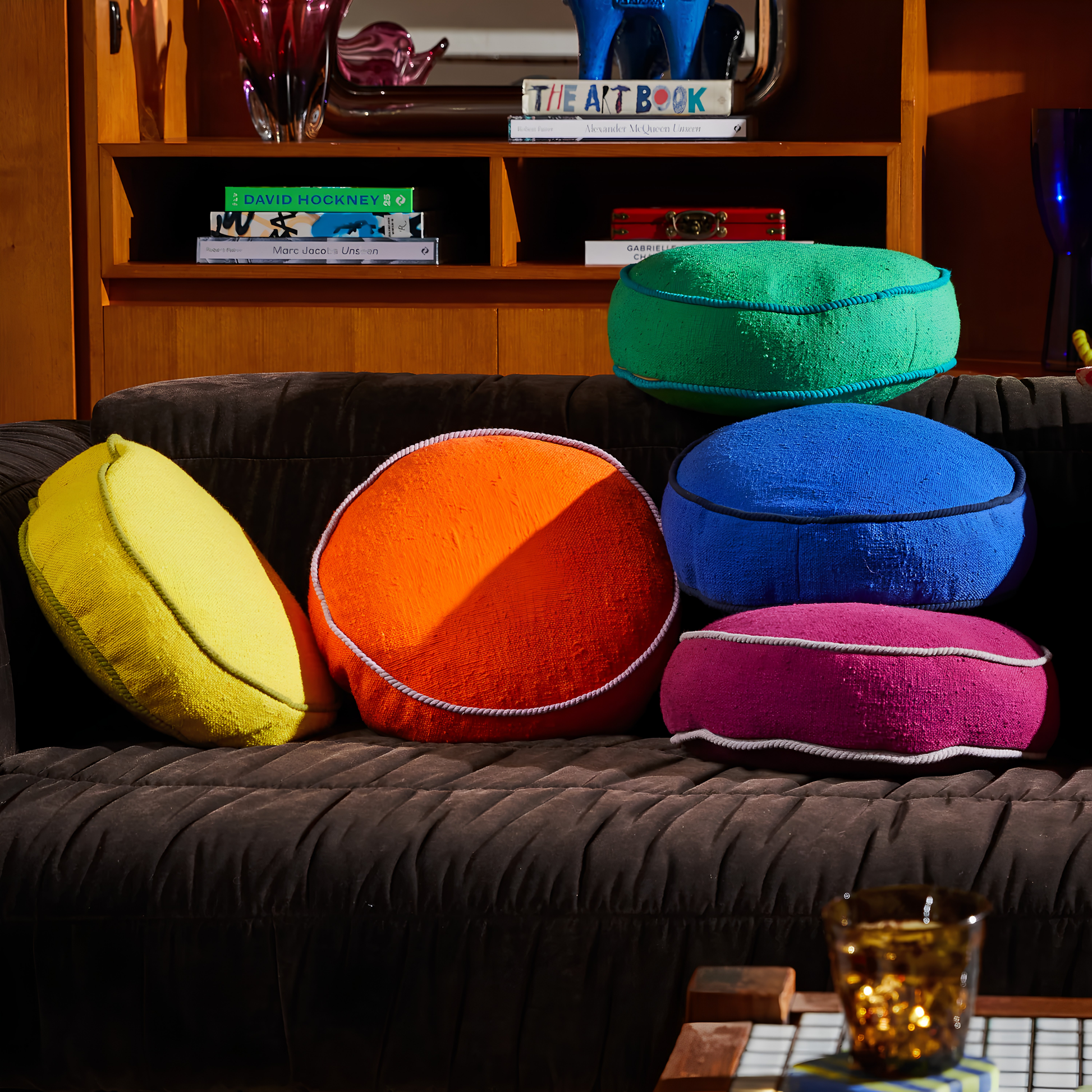 Shown on the couch with other colors, the Sage & Clare Cushion Dana Round Ultramarine made from cotton in block colours, with contrasting cord piping and high quality insert.